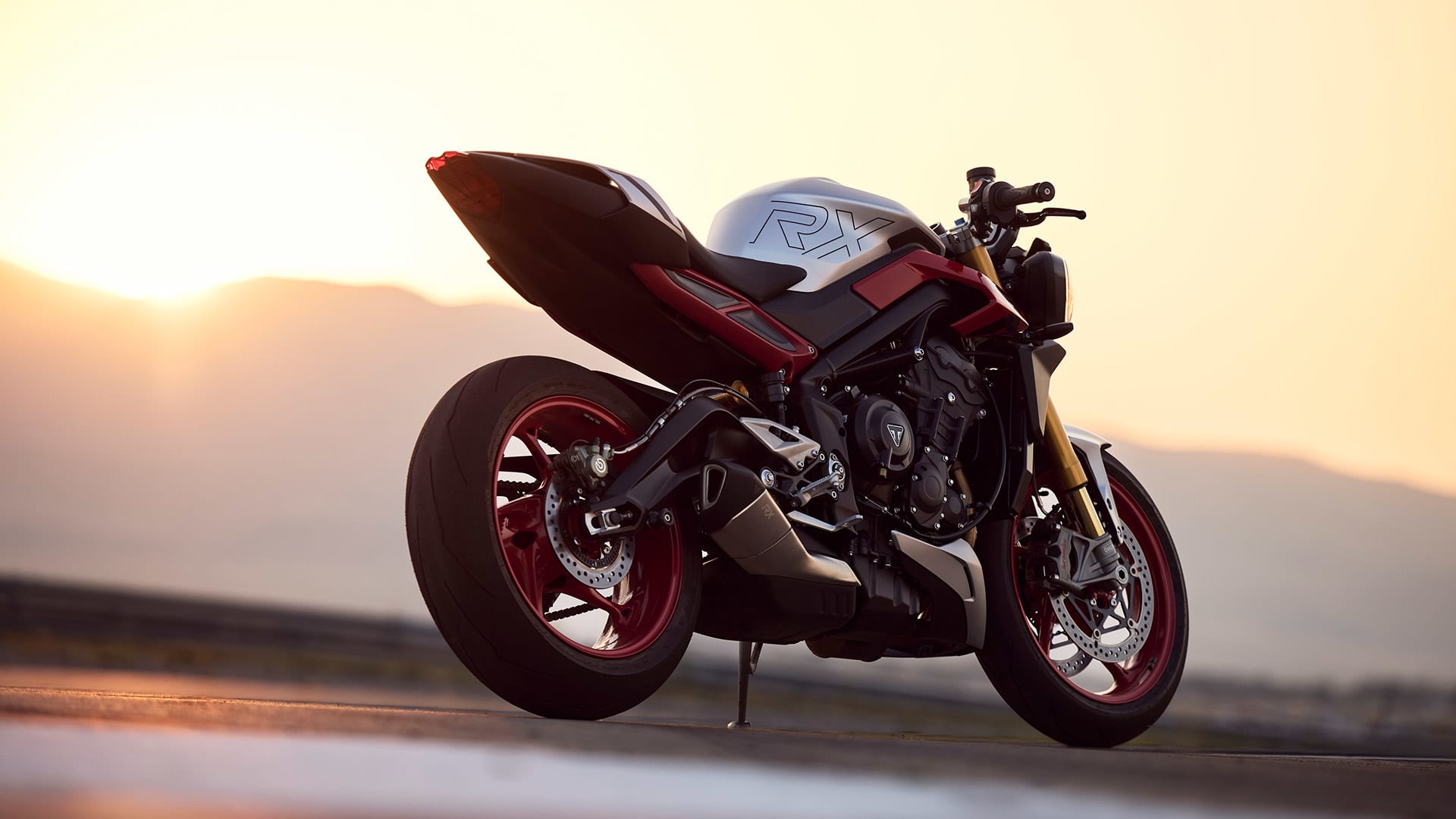 Right side angled view of Triumph Street Triple RX with sunset in the background