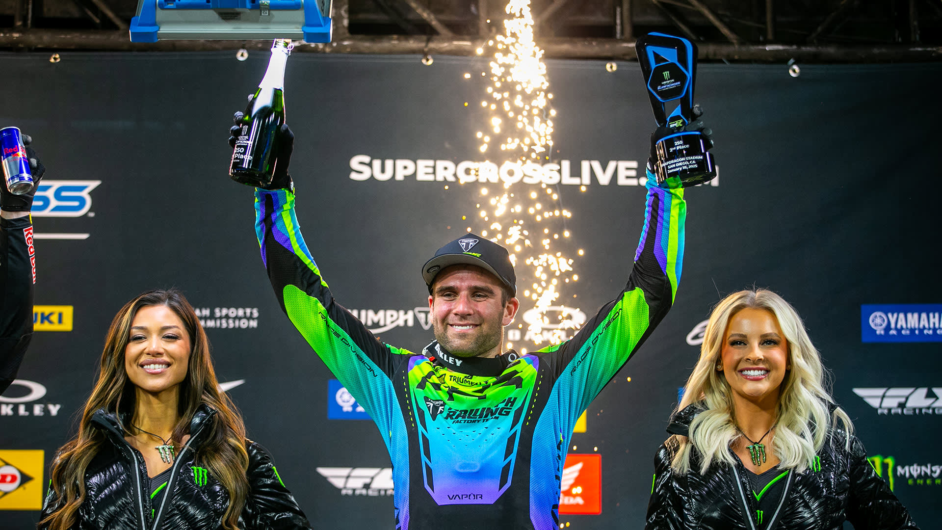 Jordan Smith raising his arms holding trophy and champagne