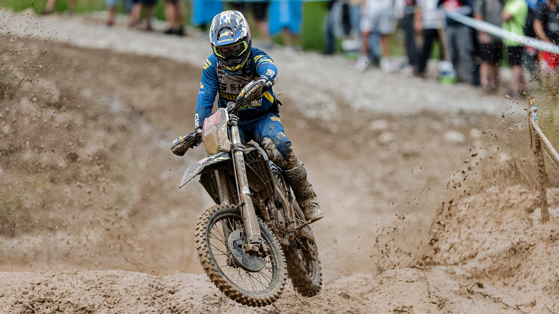Man riding Triumph Racing Motorcyle through mud