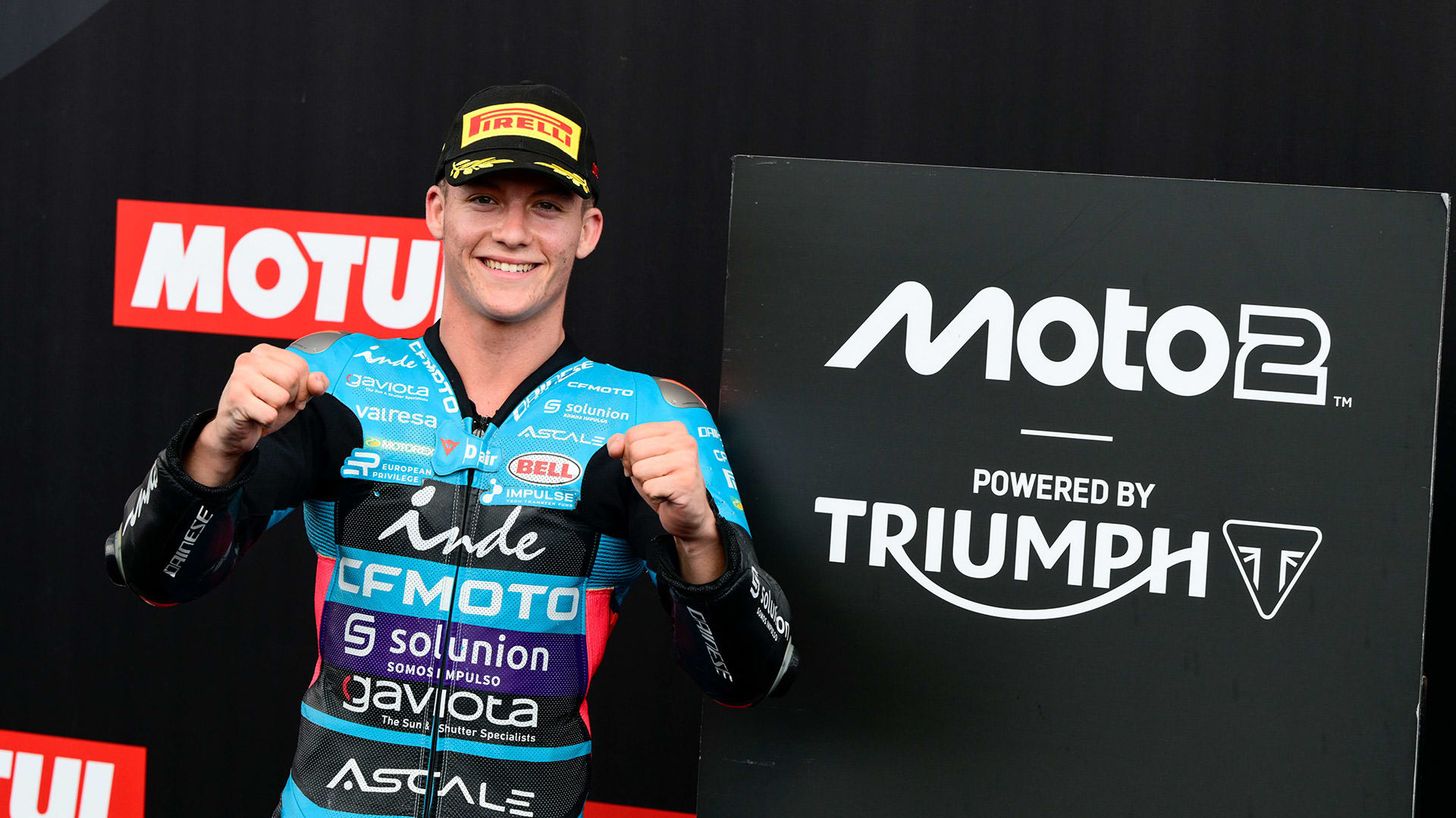 Man standing next to Moto2 sign