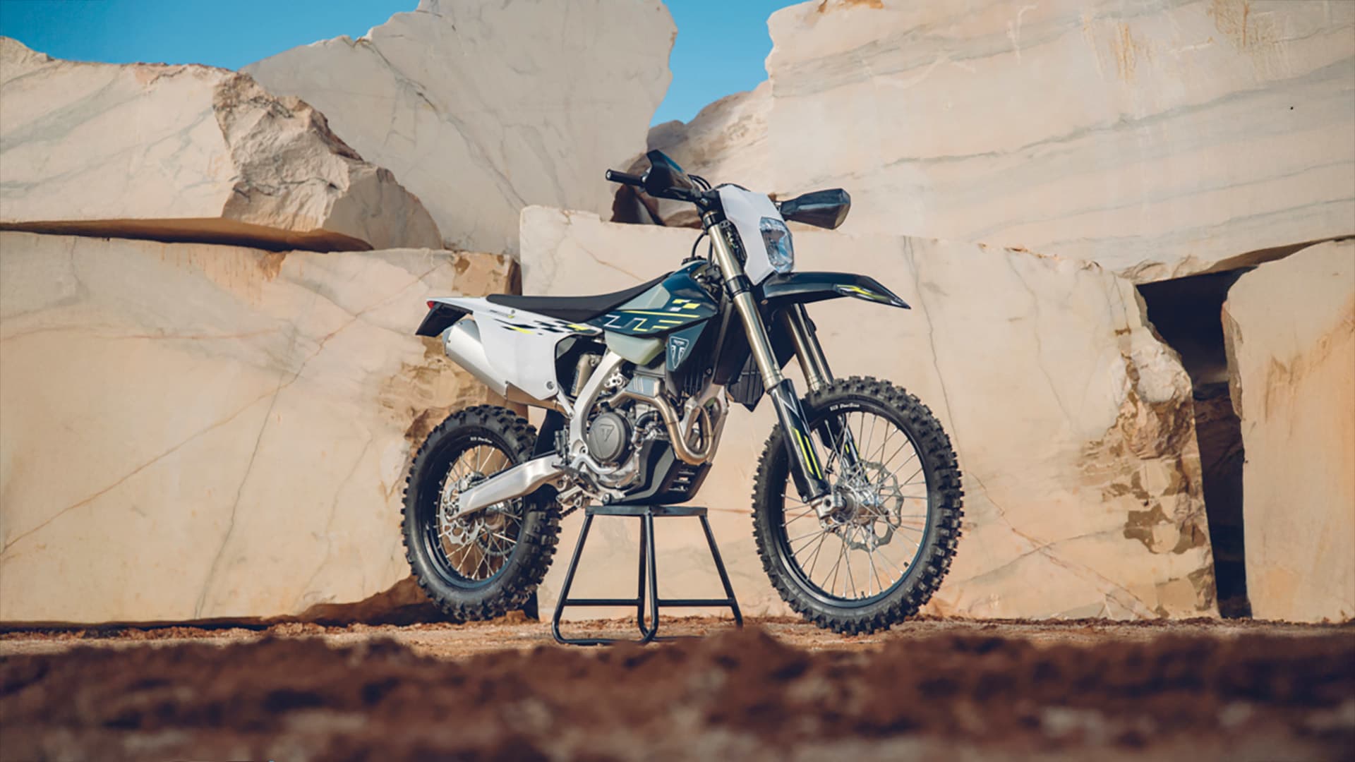 Stationary Triumph TF 250 E in front of a wall of rocks
