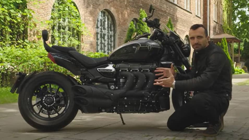 Man crouching next to Triumph Rocket 3 Storm