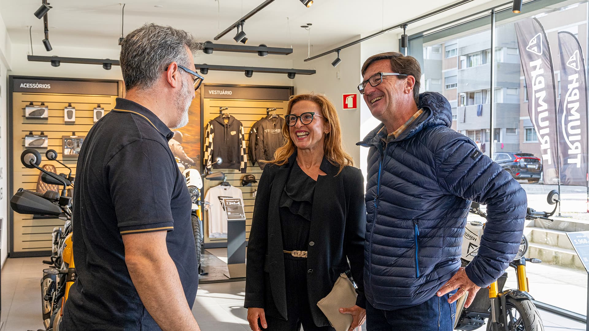 Three people speaking together at Triumph Porto opening day