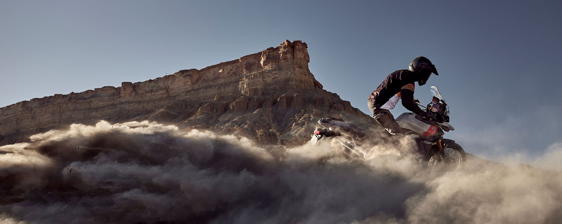 Triumph Tiger 900 Rally Pro riding through the sand)