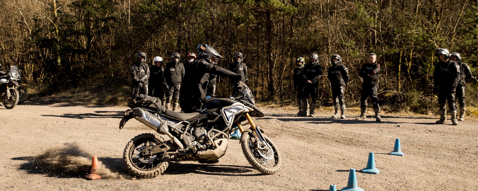 Man riding Triumph Tiger Motorcycle on dusty path