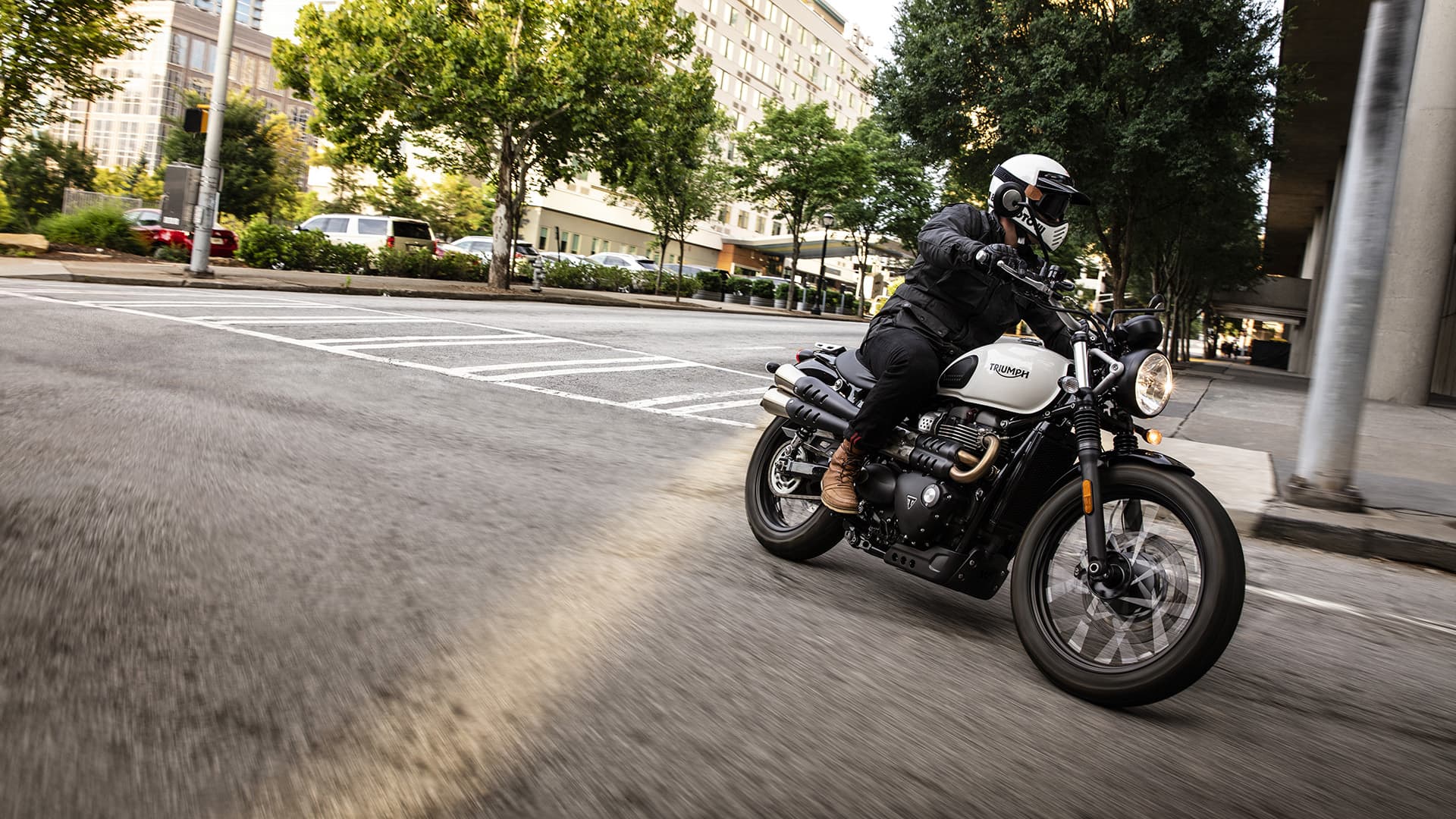 Triumph Street Scrambler riding on city street turning through a corner