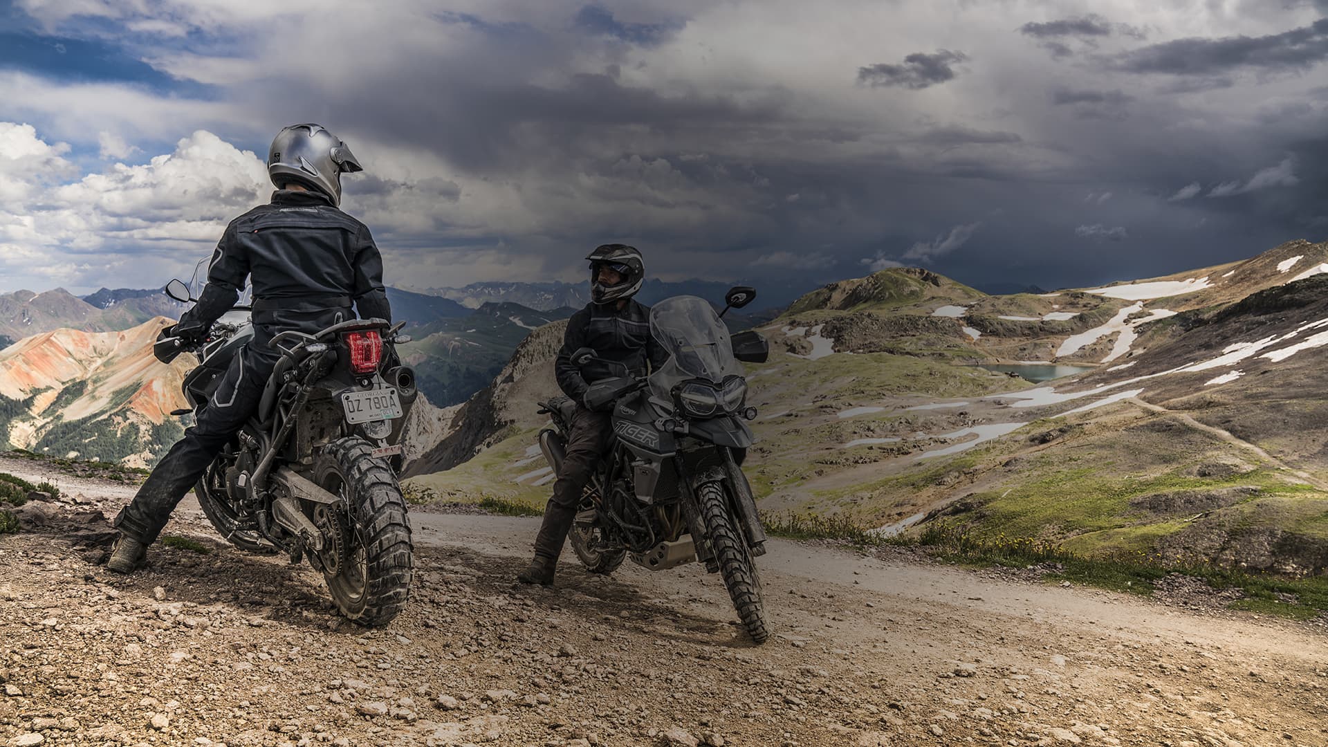 Two people stopped in the mountains on Tiger 800s.