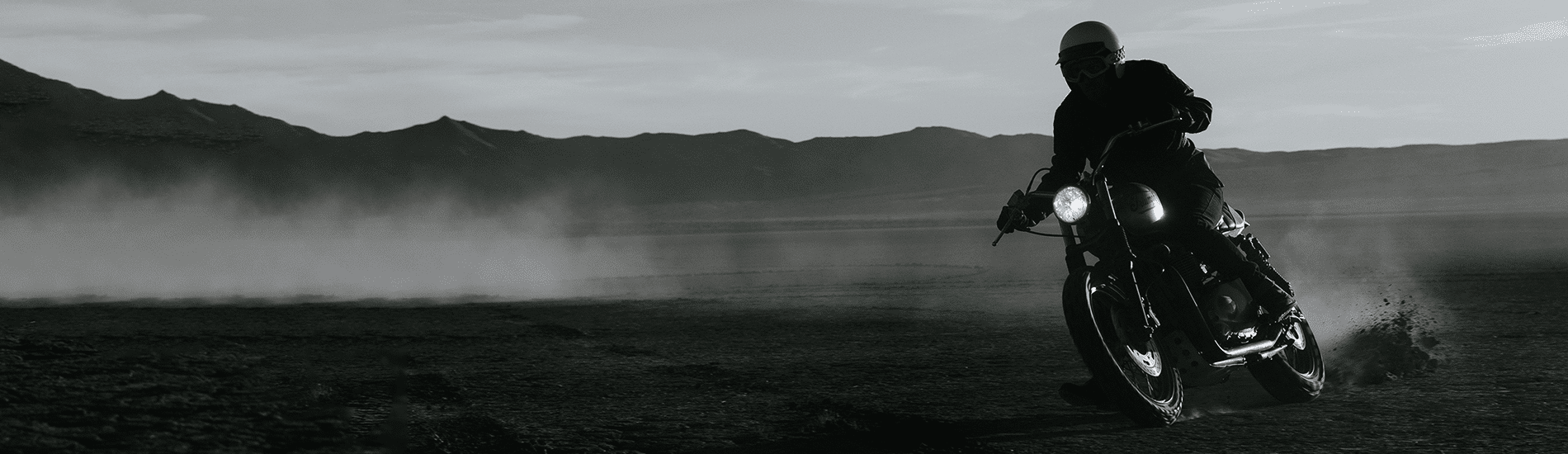 Male rider riding across the desert)