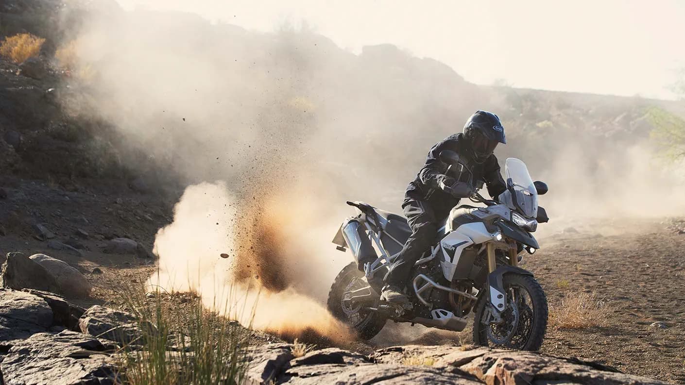 Off road riding shot of a Triumph Tiger 900 Rally Pro kicking up a cloud of dust