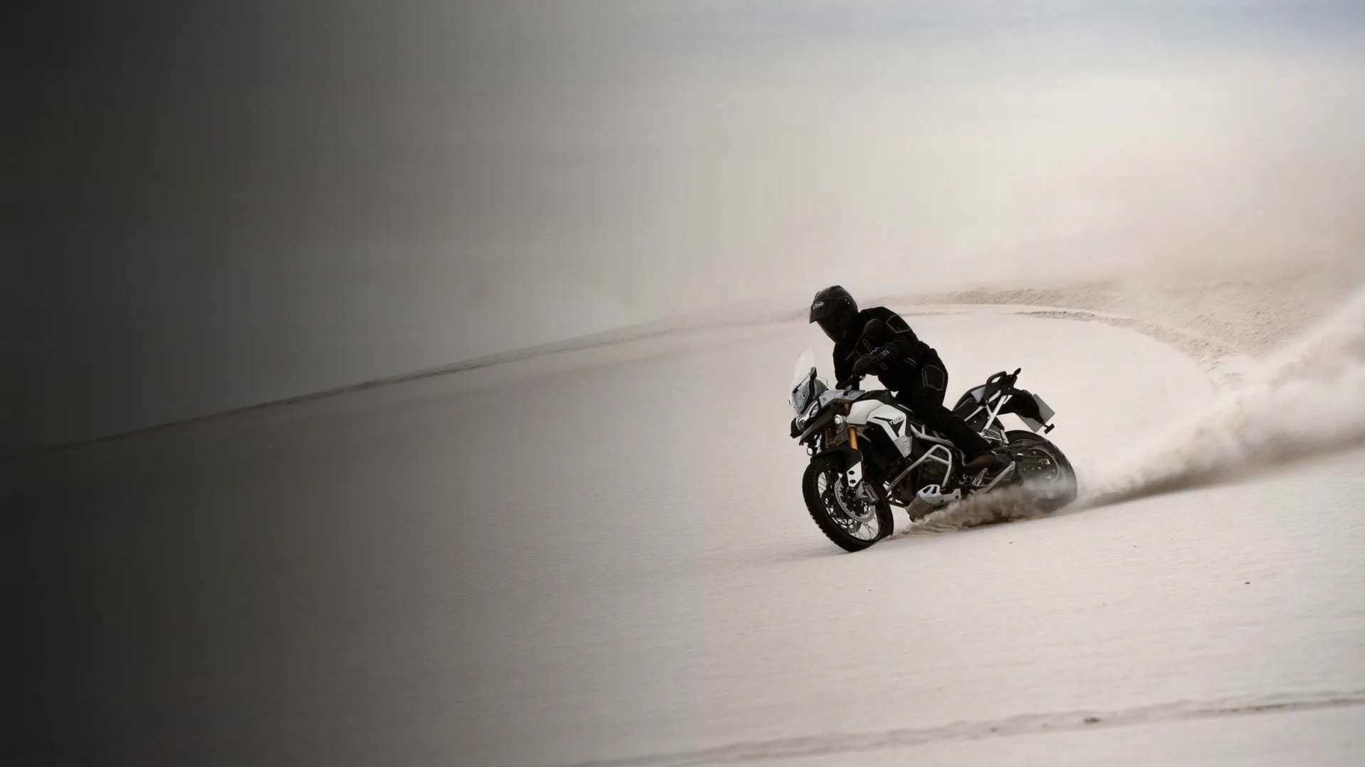 Triumph Tiger 900 Rally Pro crossing over the white dunes in South Africa