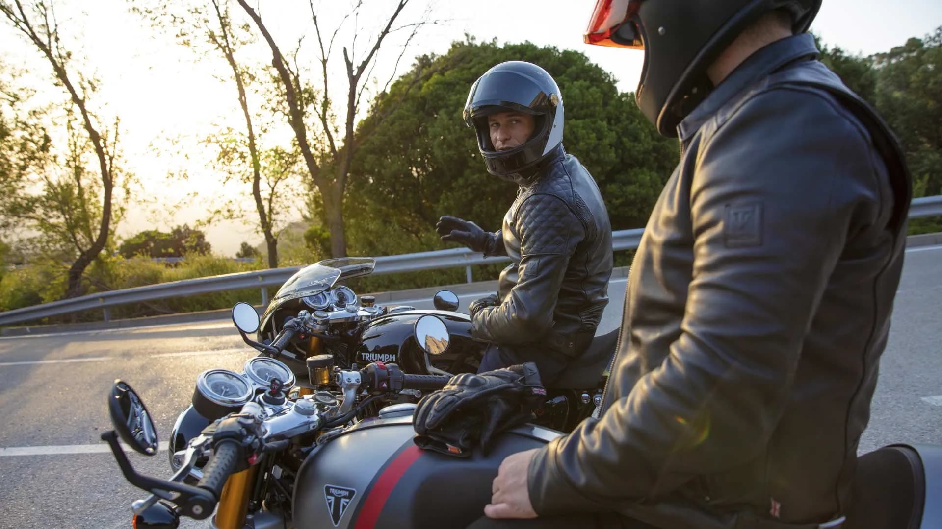 Two riders taking a moment to chat together on their Triumph Thruxton RS motorcycles