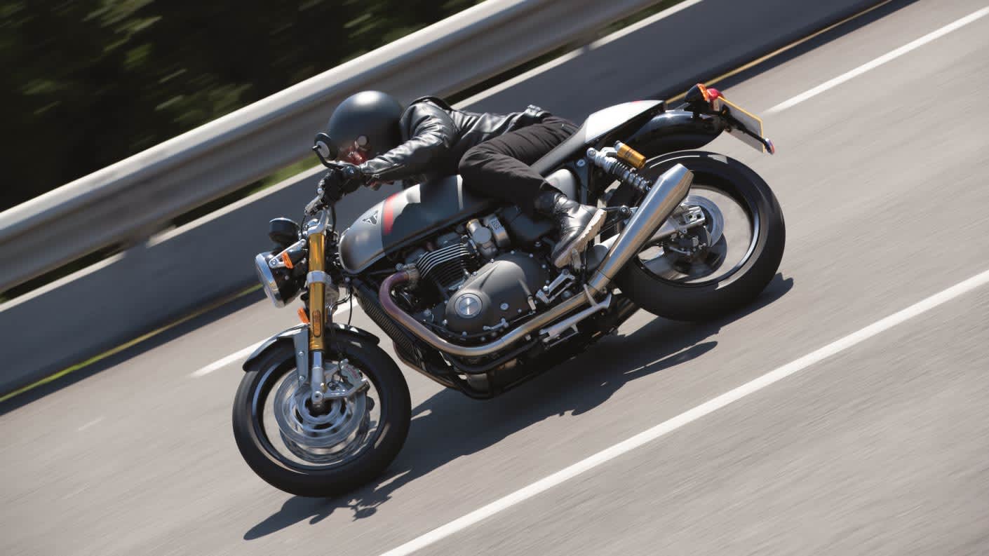 Rider accelerating down a straight road and testing the power of their Triumph Thruxton RS