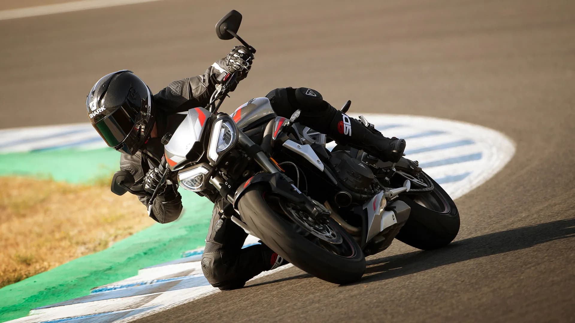 Action shot of Triumph Street Triple RS in Silver Ice powering through a corner