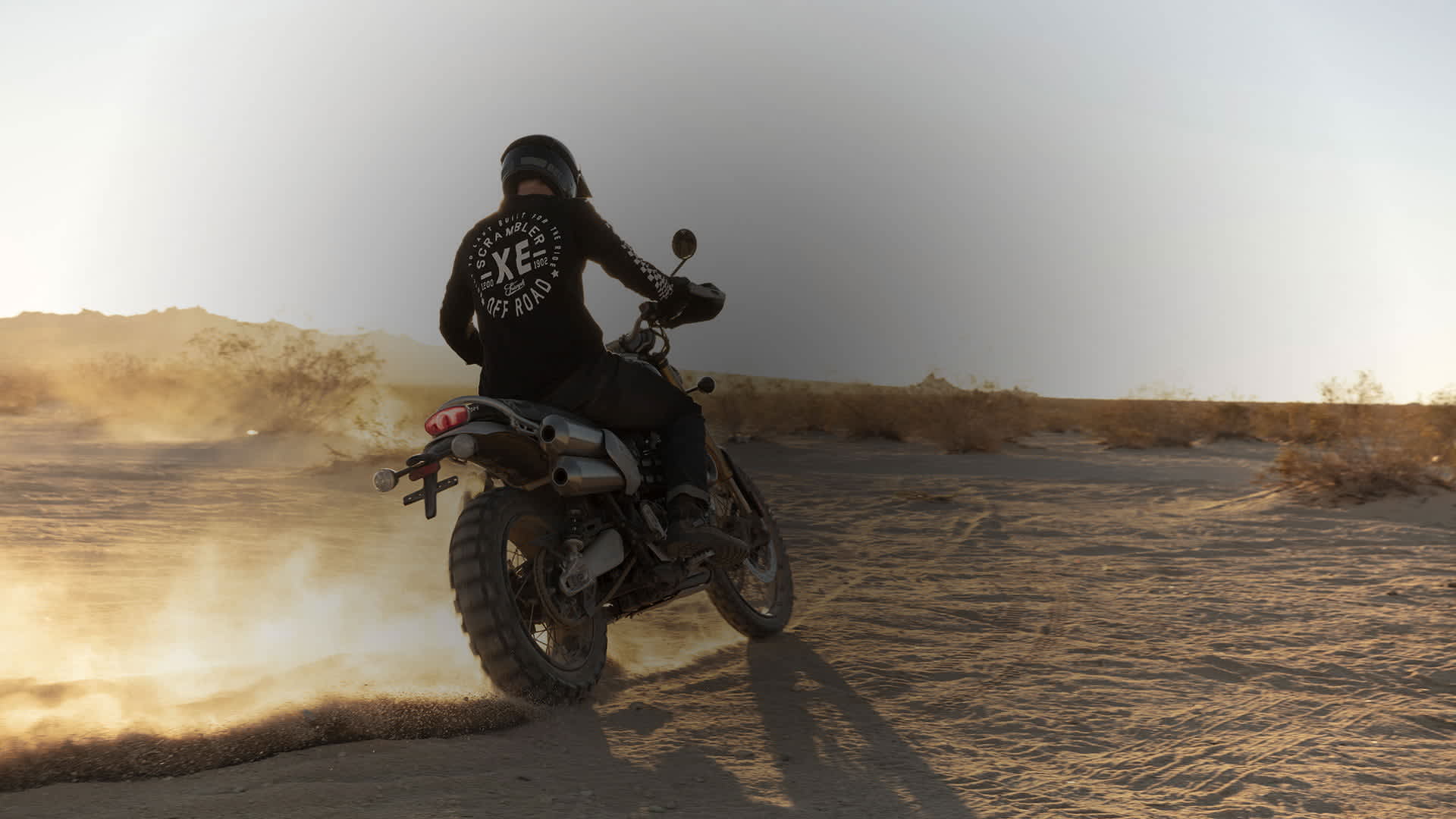 Person riding a Scrambler 1200 through a desert. 