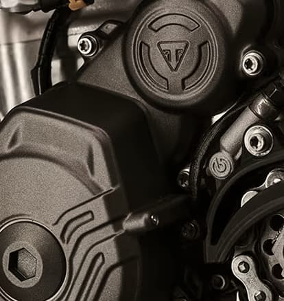 Close-up of the rear wheel, chain and sprocket on a Triumph off-road motorcycle.