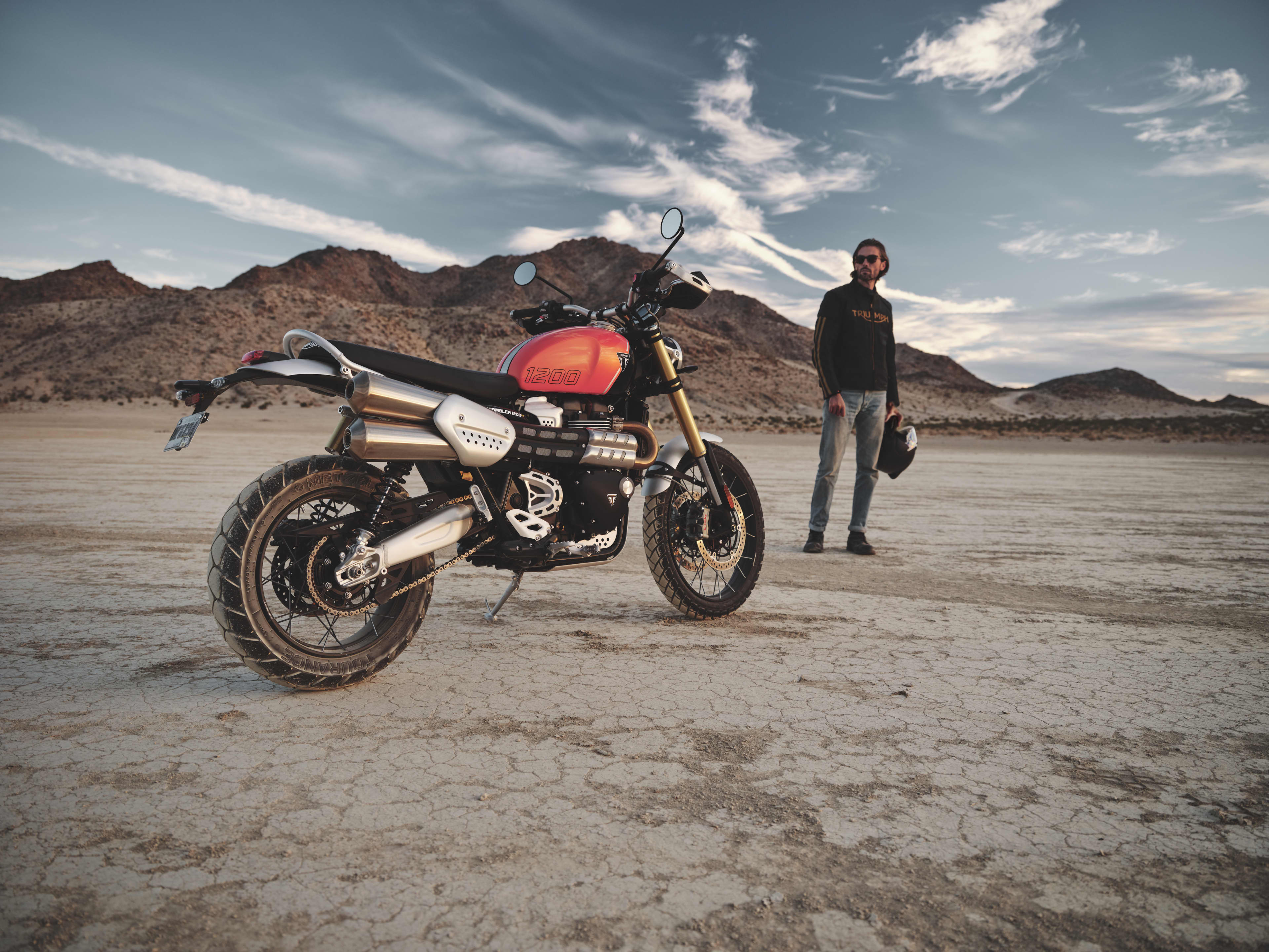 Front view of Triumph Scrambler 1200 XE cruising through a dirt track