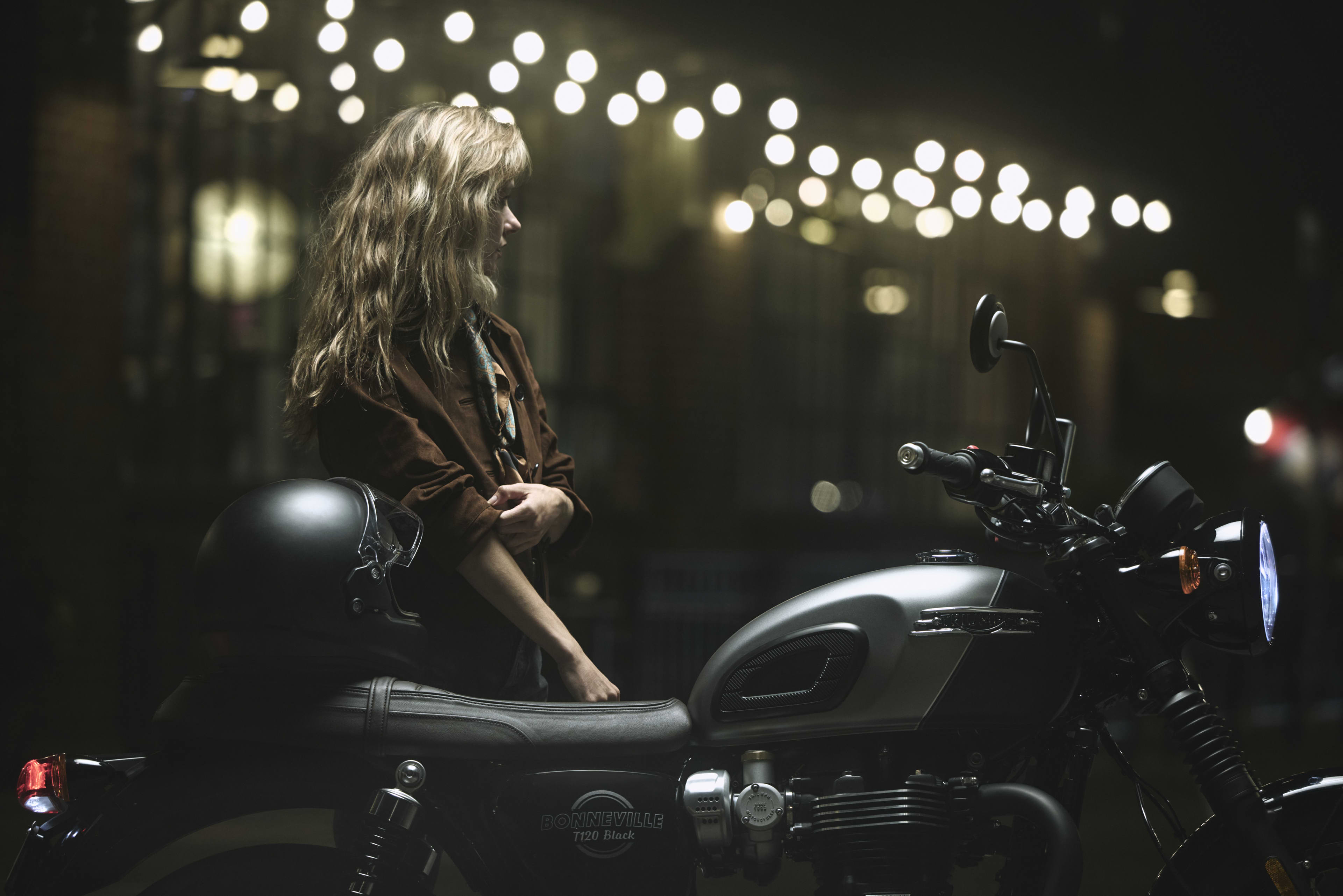 A lady standing next to the Triumph Bonneville T120 Black