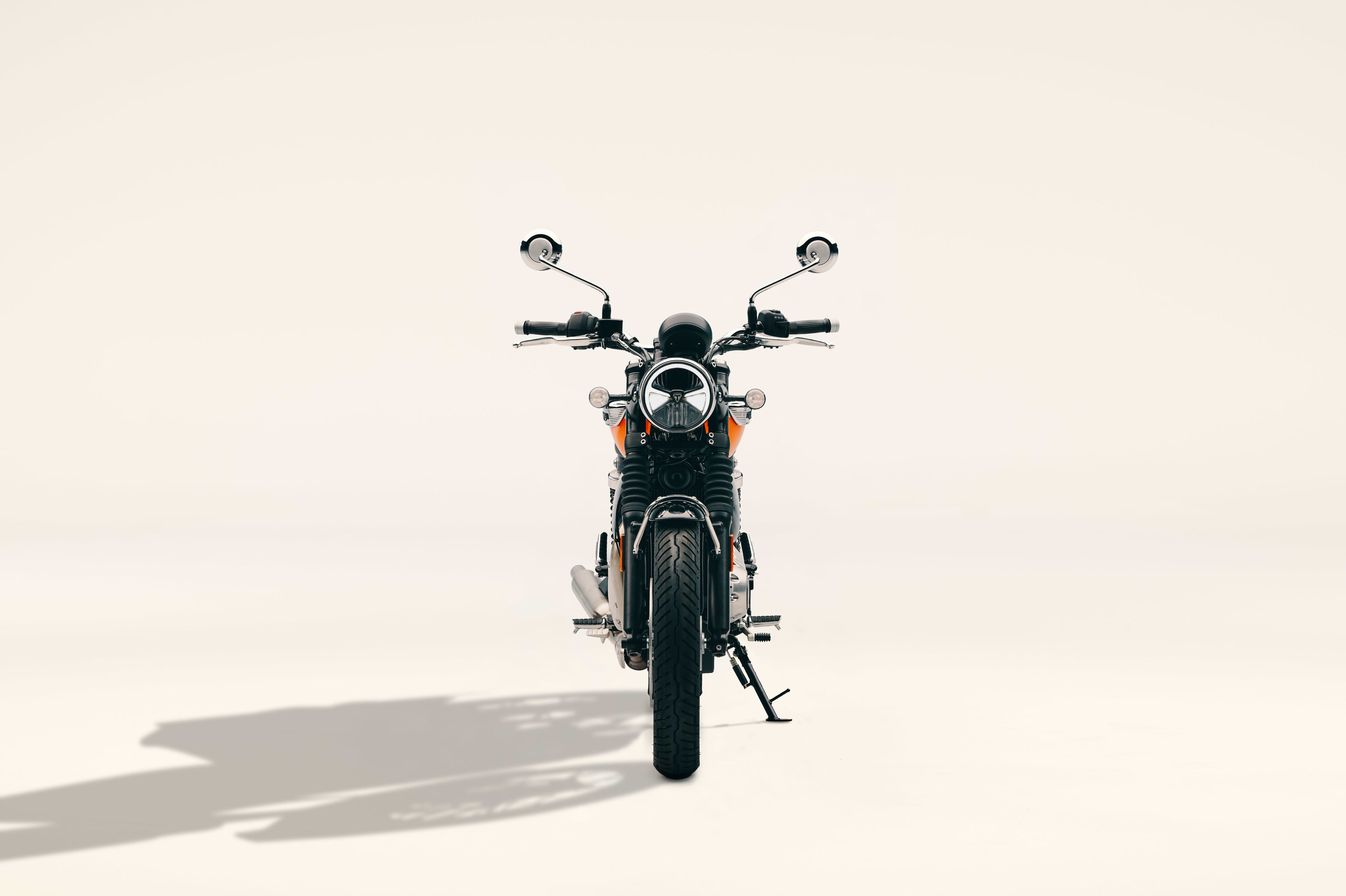 Direct front profile of a Triumph Bonneville T40 motorcycle with round headlight and mirrors in a studio setting.