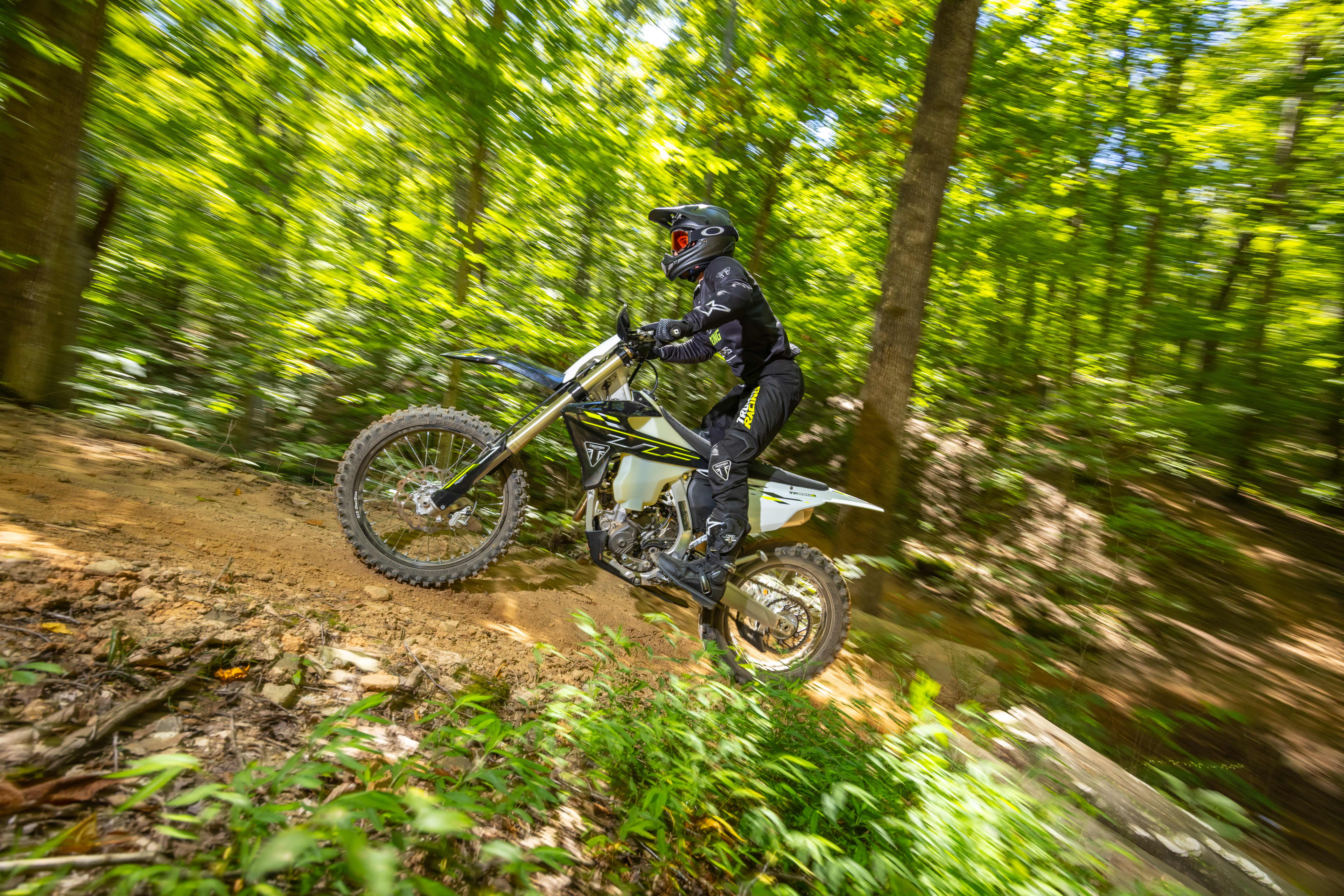 Triumph Cross Country motorcycle riding through the forest