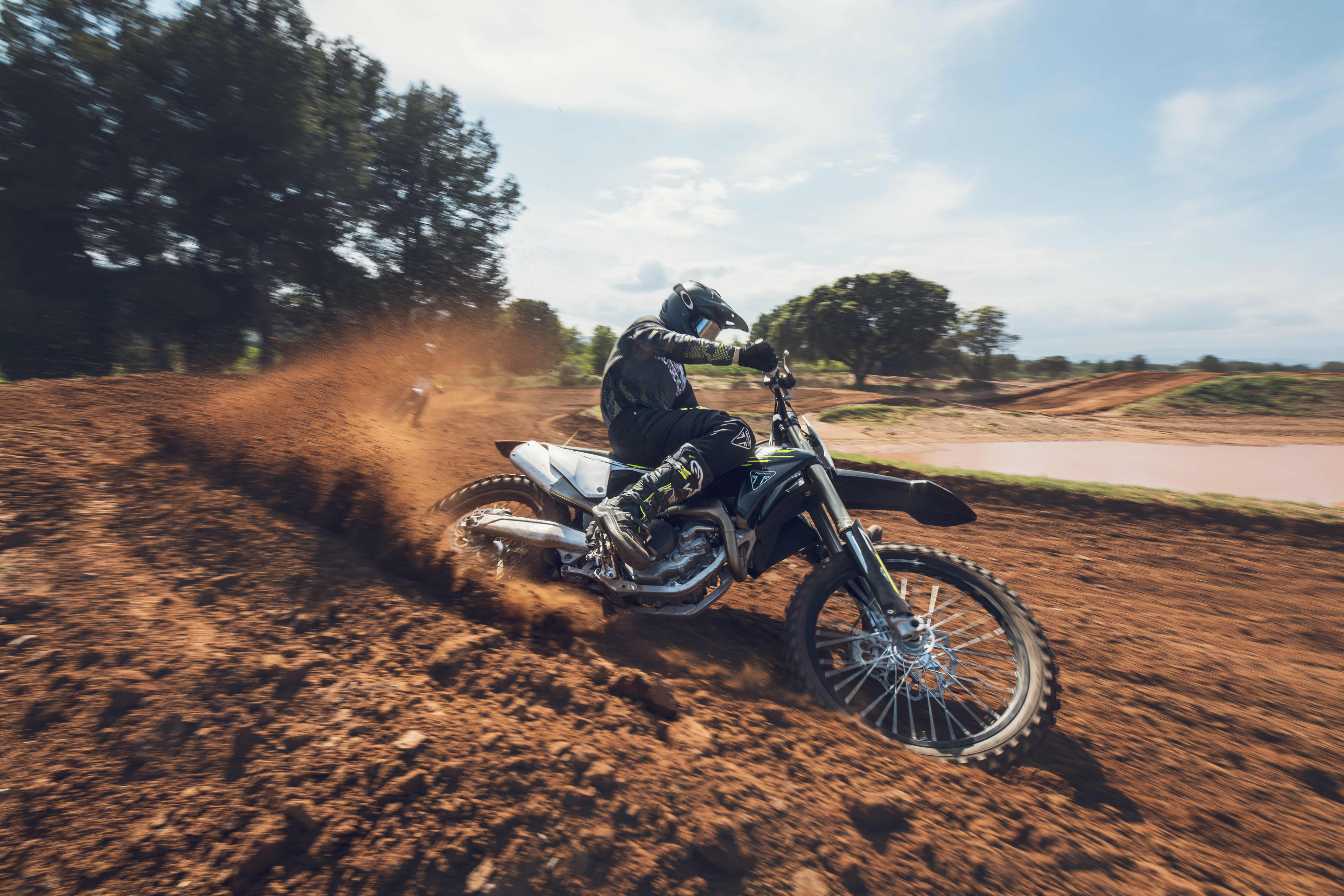 Gefabriceerde swingarm Rider on the TF 450-X motorcycle doing tricks through the red dirt track