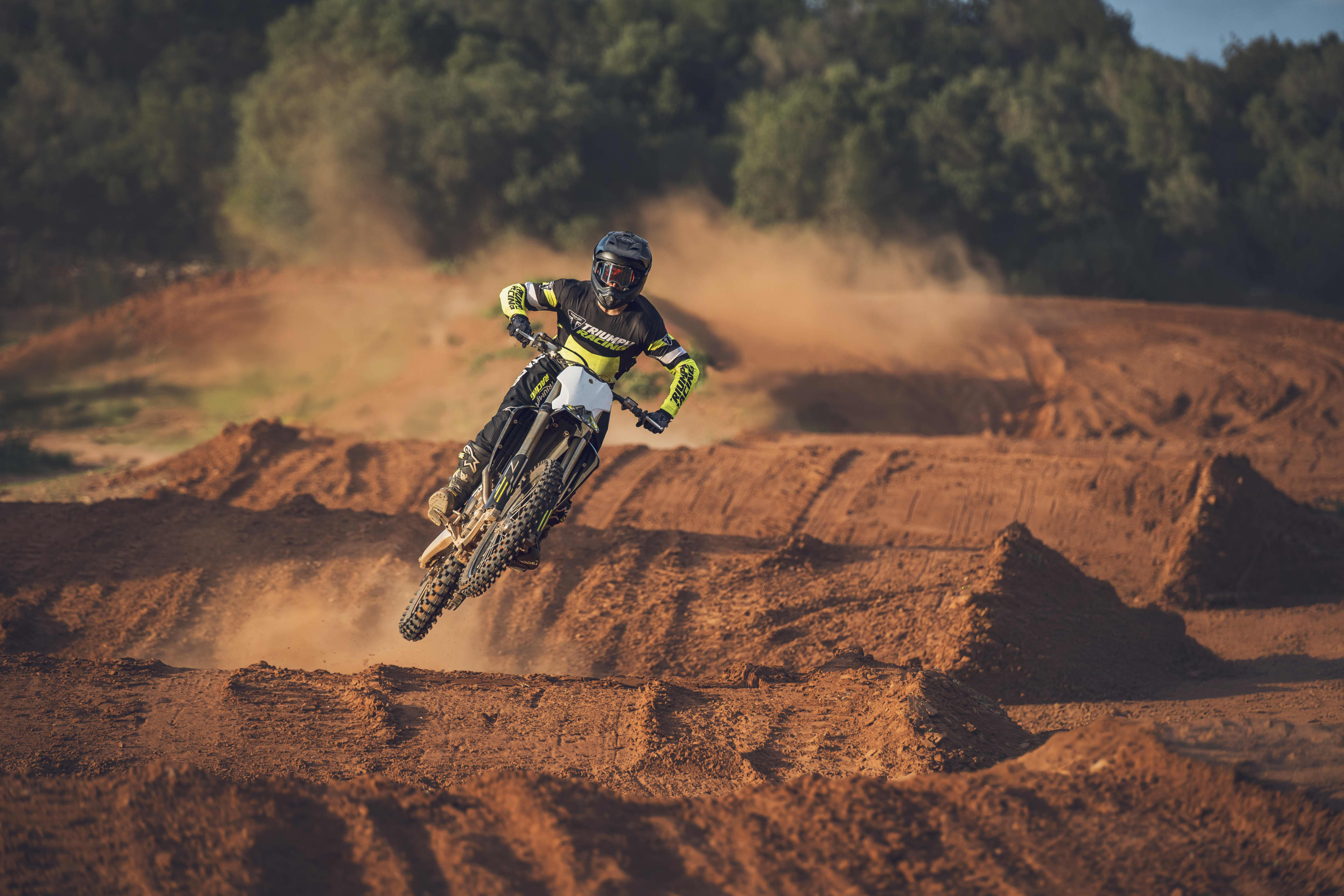 TF 450-X with rider going over dirt ramps