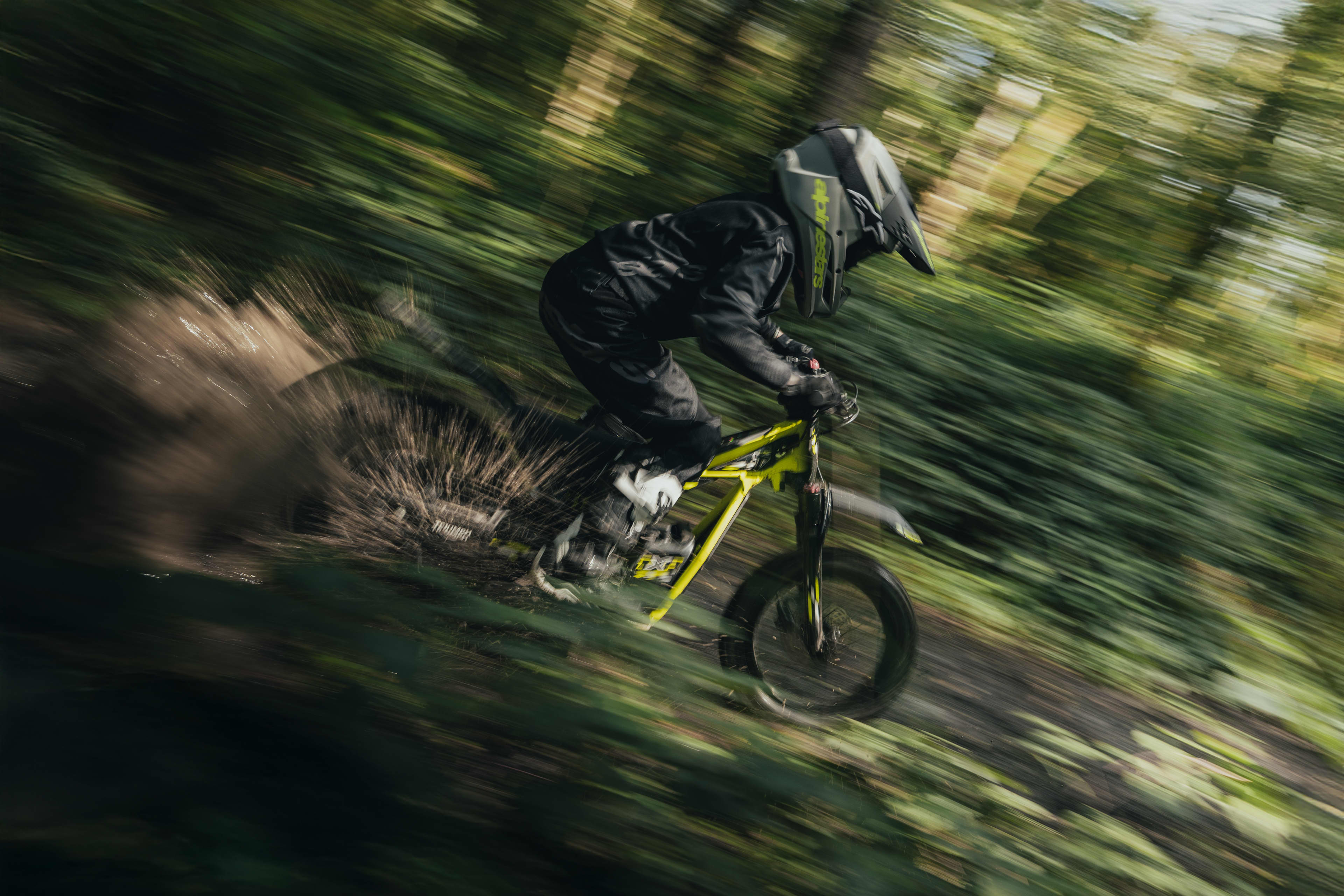 Young rider out exploring the muddy forest trail on the Triumph TXP-16 powered by OSET bike.
