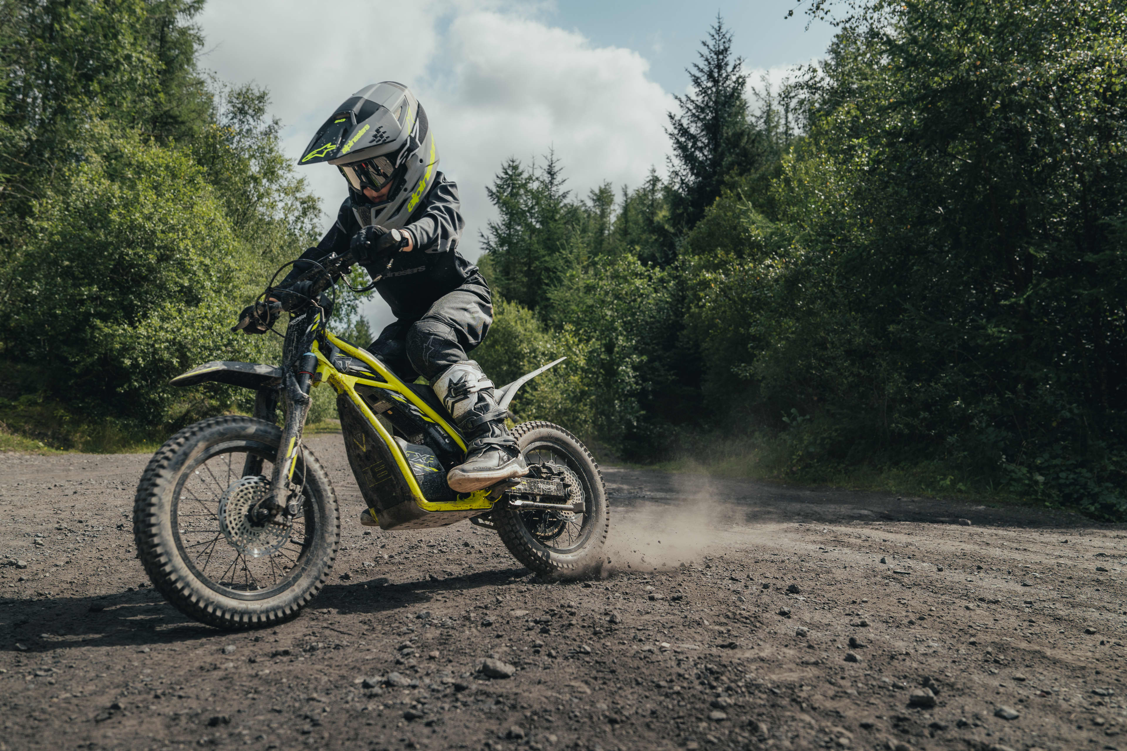 Ung kører på en elektrisk Triumph TXP-16-offroadmotorcykel.