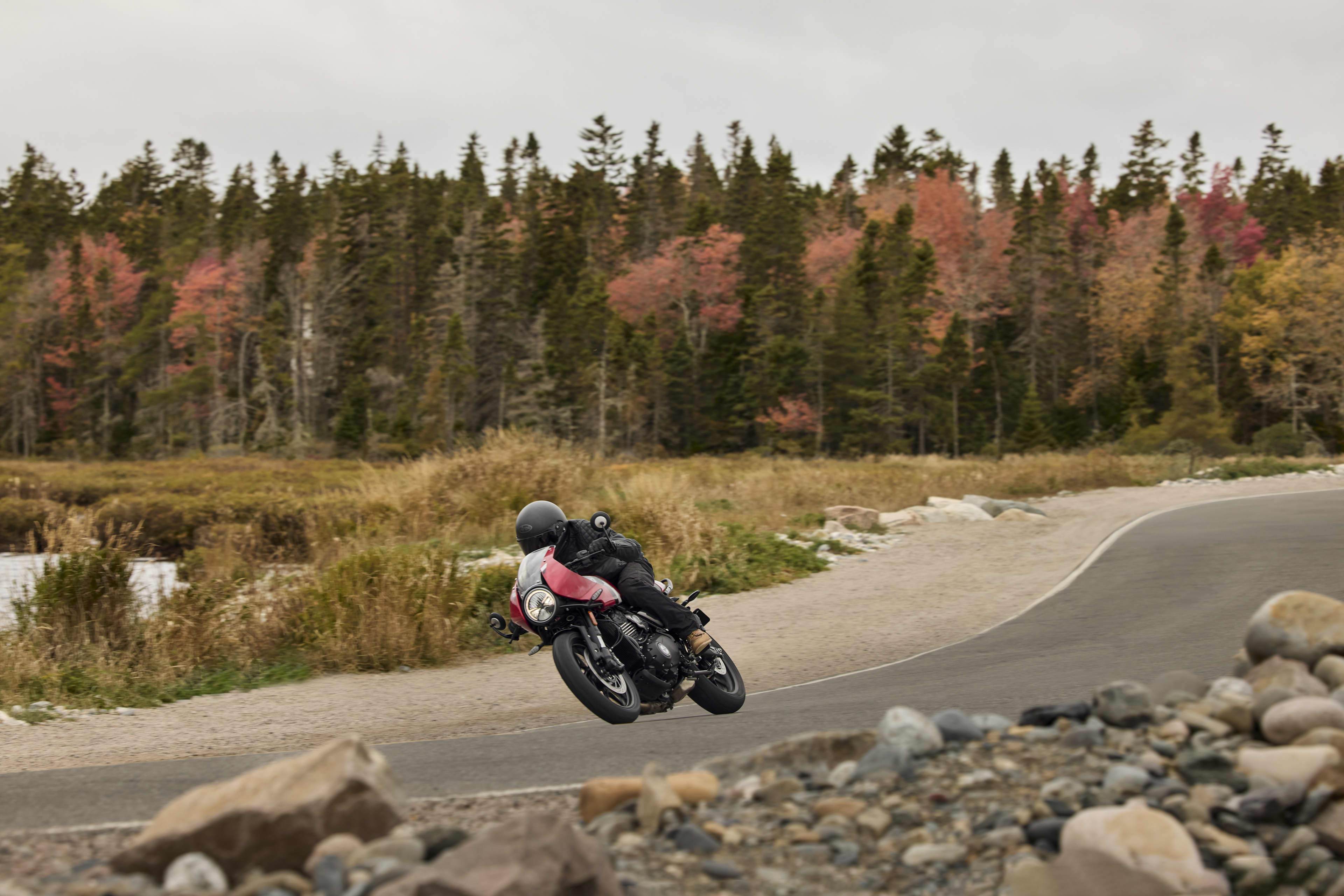 Angled left side view of rider on Thruxton 400 on a road