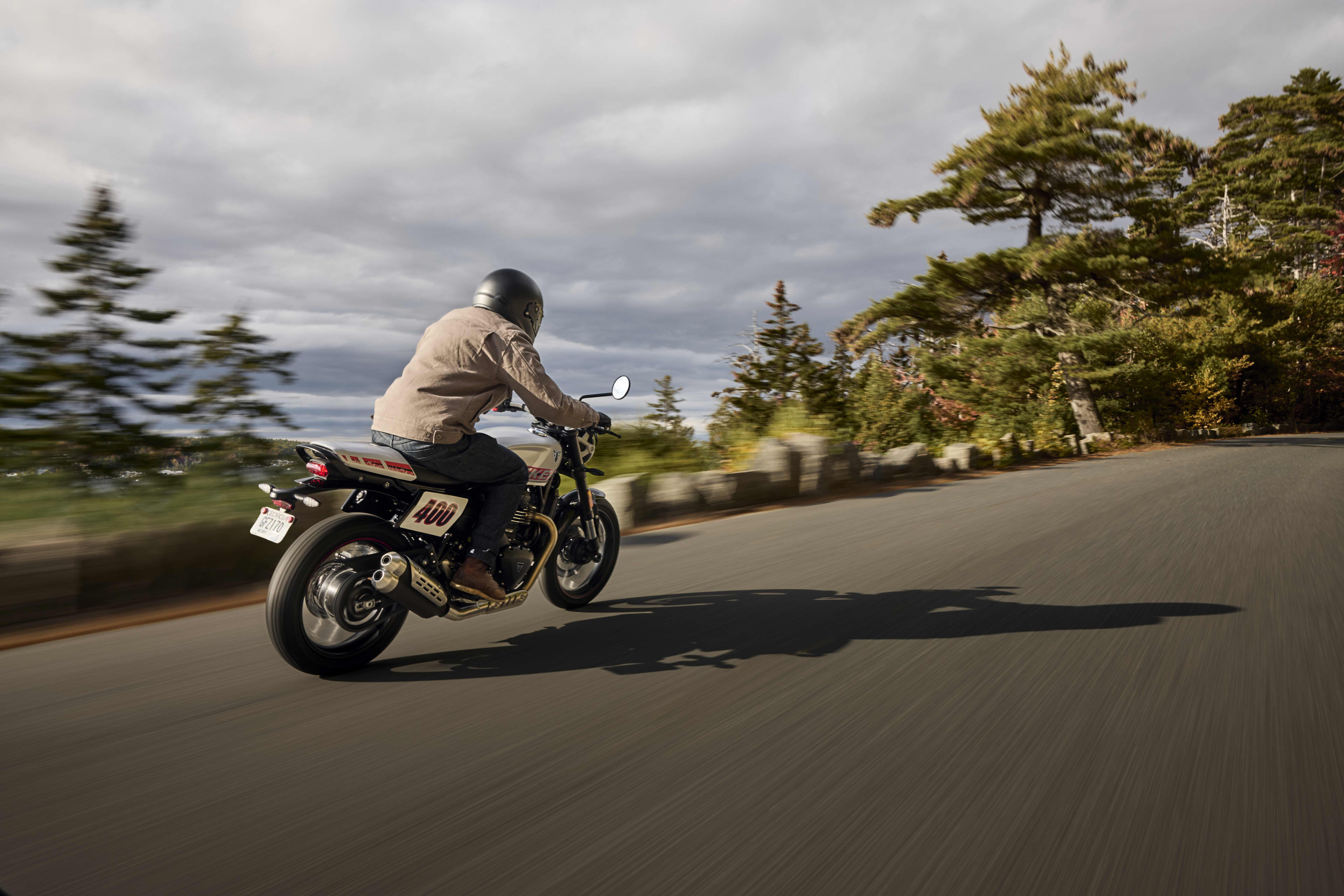 Angled right side riding shot of Tracker 400 on a road towards a forest