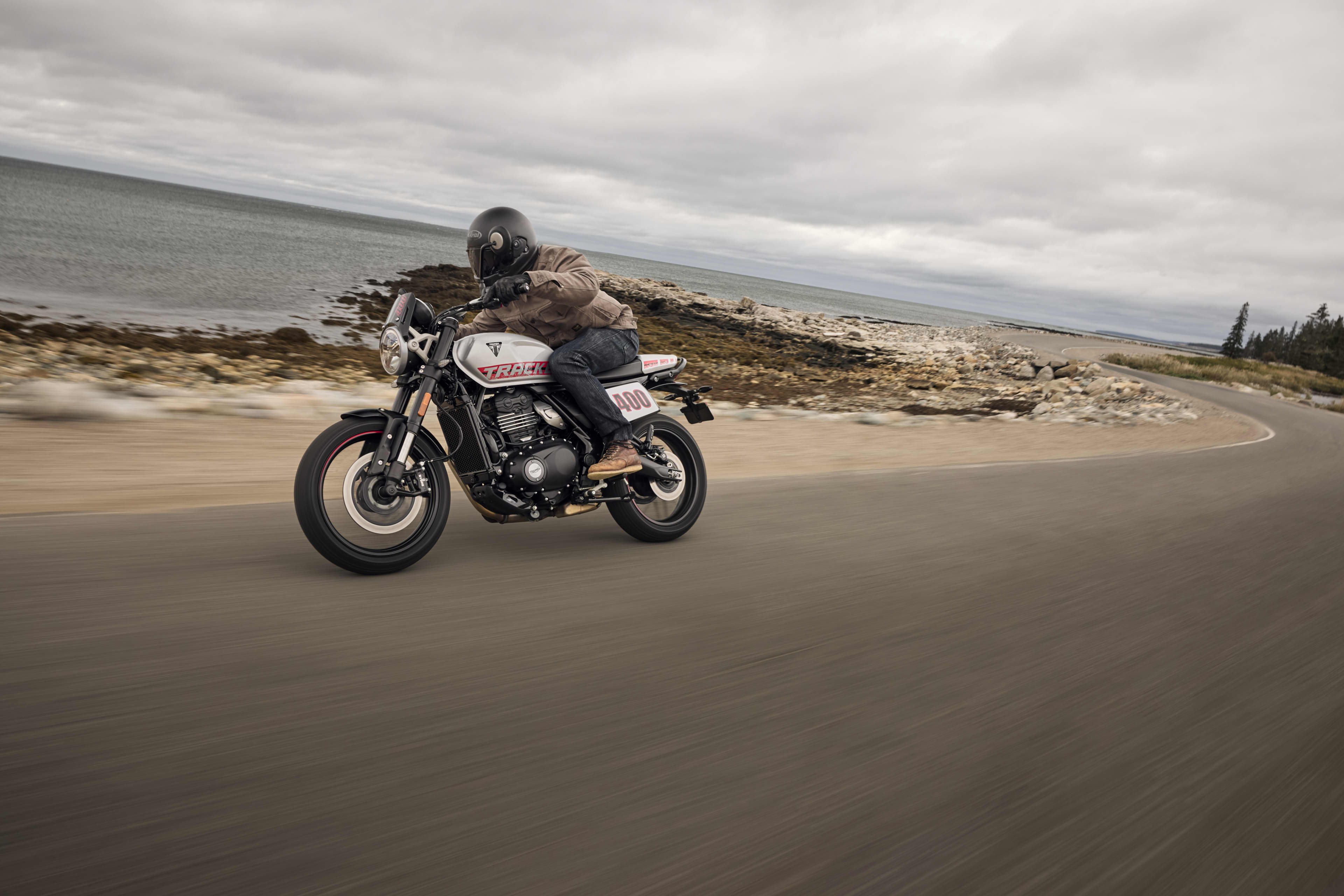 Triumph Tracker 400 riding shot on the coast