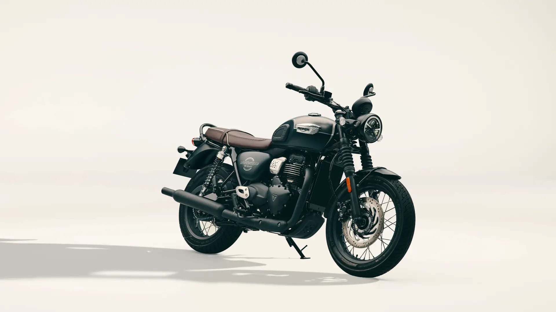 Studio shot of a satin grey and black Triumph Bonneville T40 Black motorcycle parked on a light background.