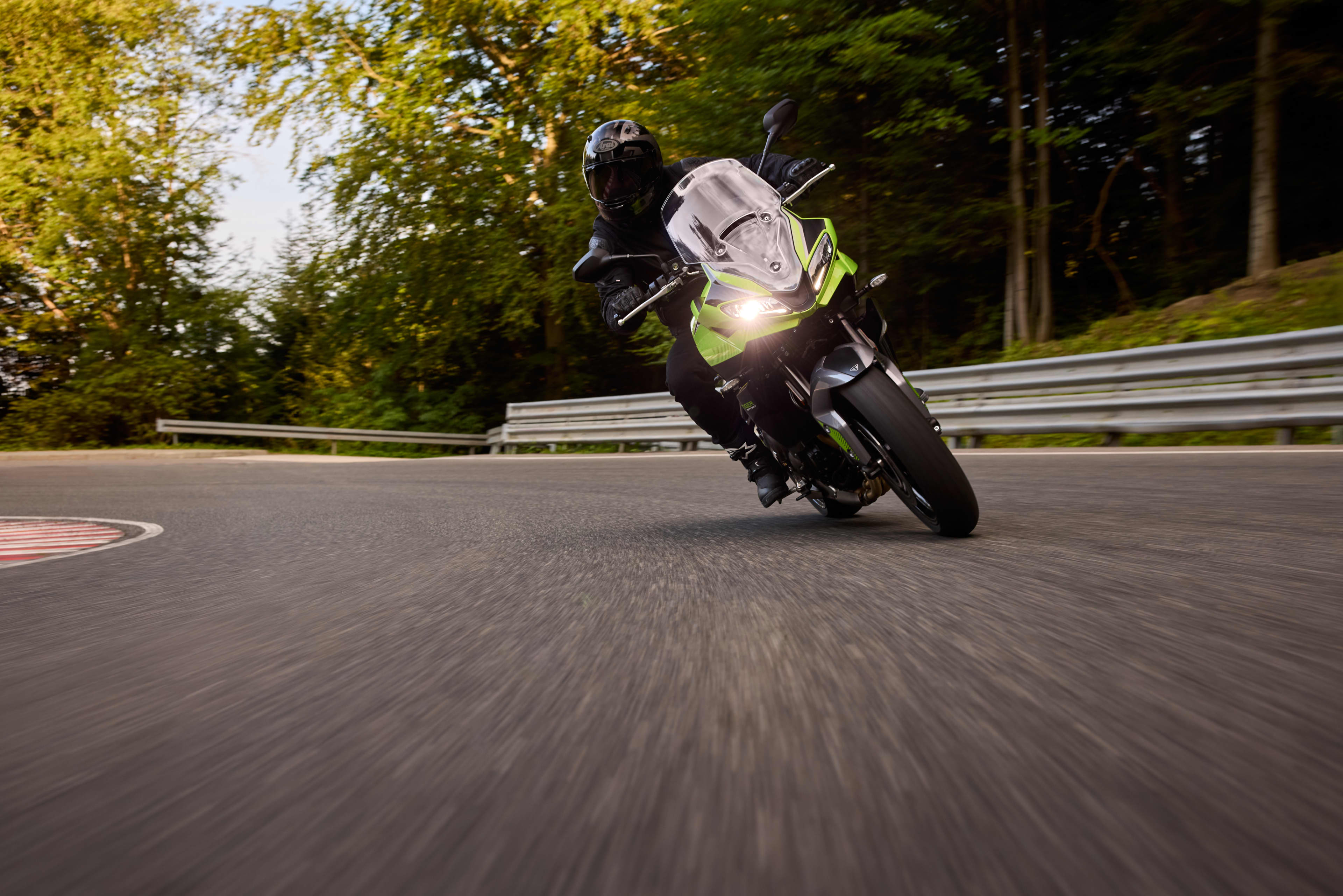 Front view of a man sat on the Tiger Sport 800 Tour in a forest