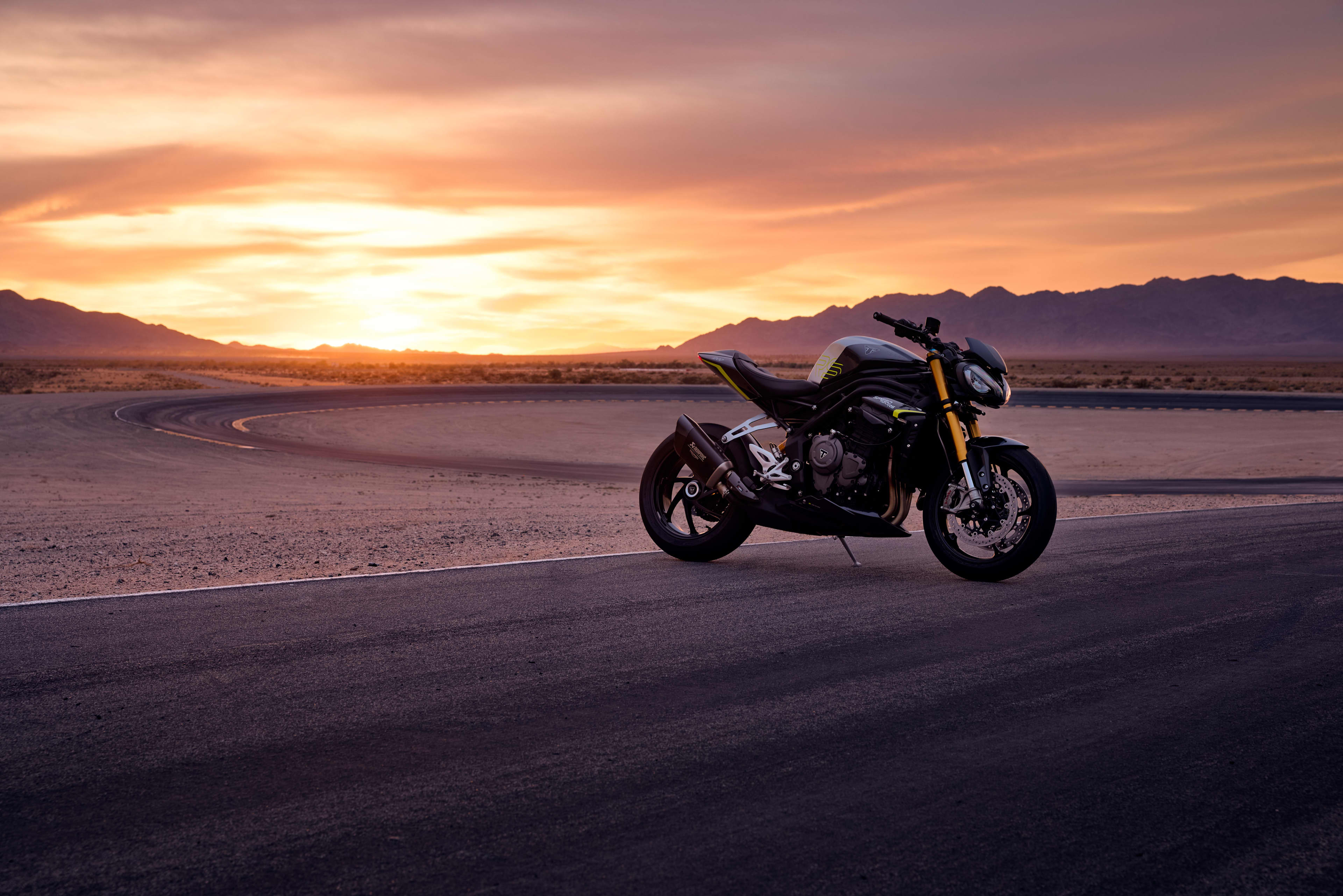 Speed Triple 1200 RS parked up on the track with the sunset in the background.