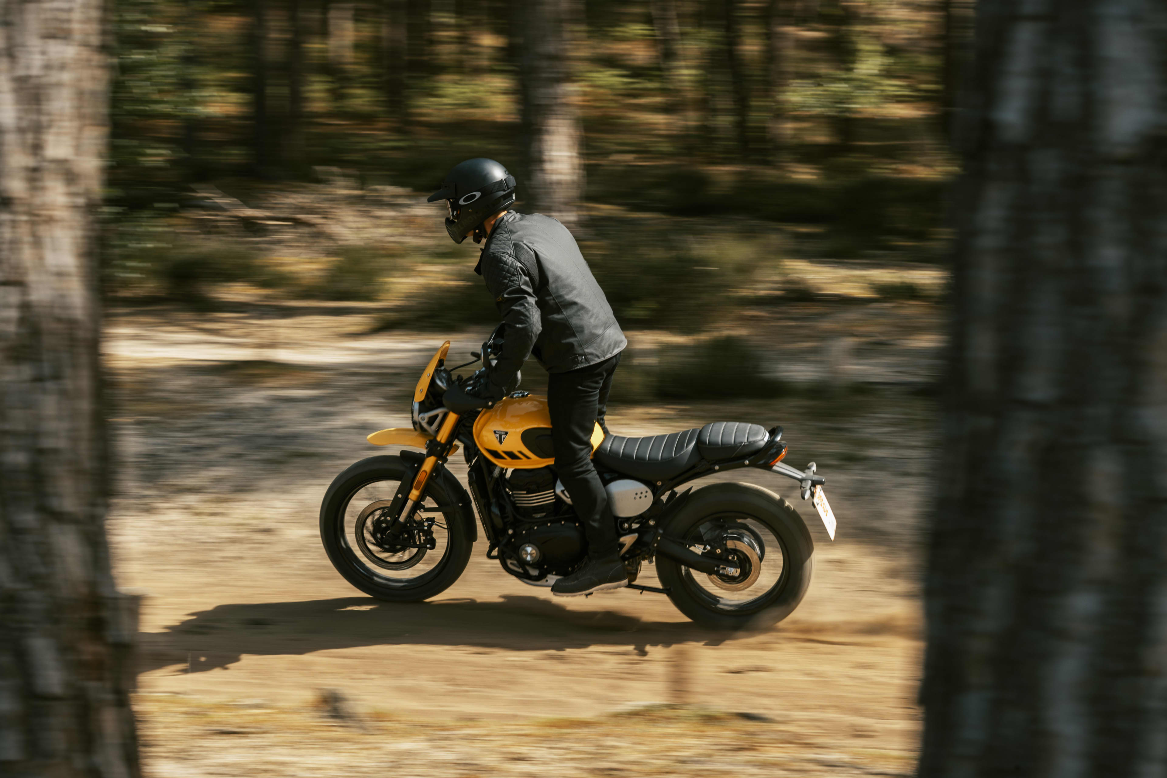 Triumph Scrambler 400 XC riding in a forest setting