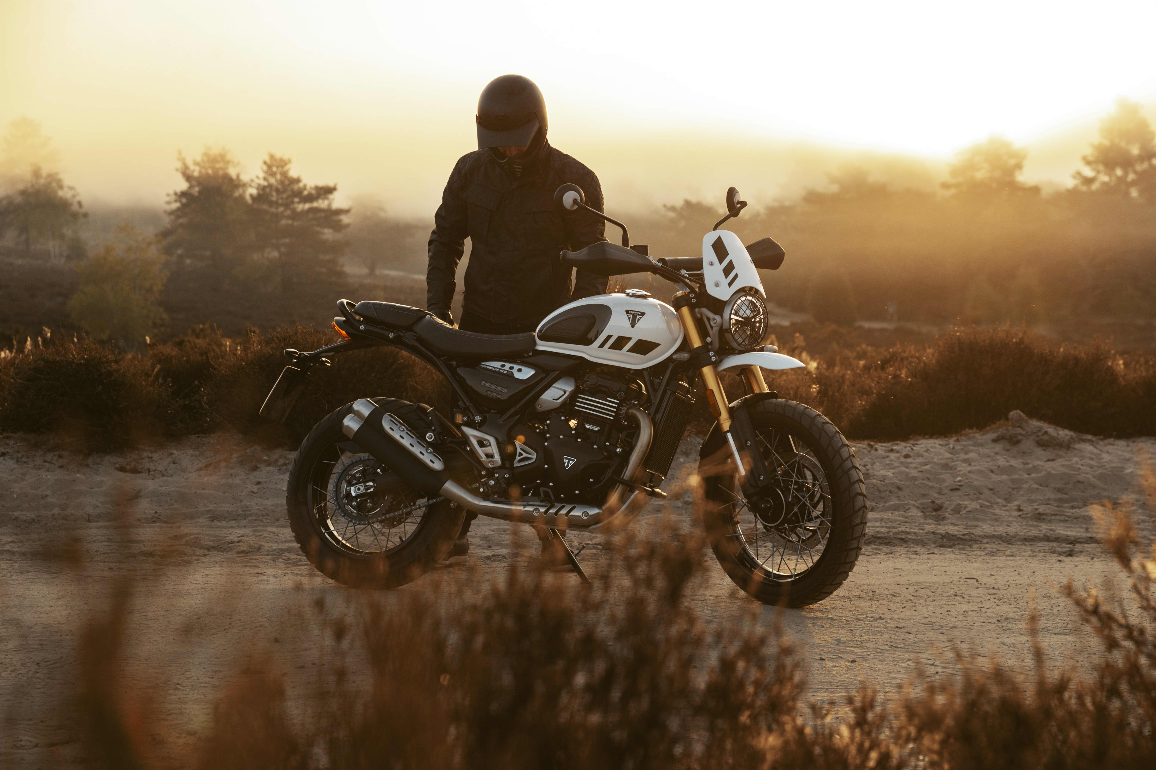 Scrambler 400 XC Triumph motorcycle, Vanilla White static shot with rider. 