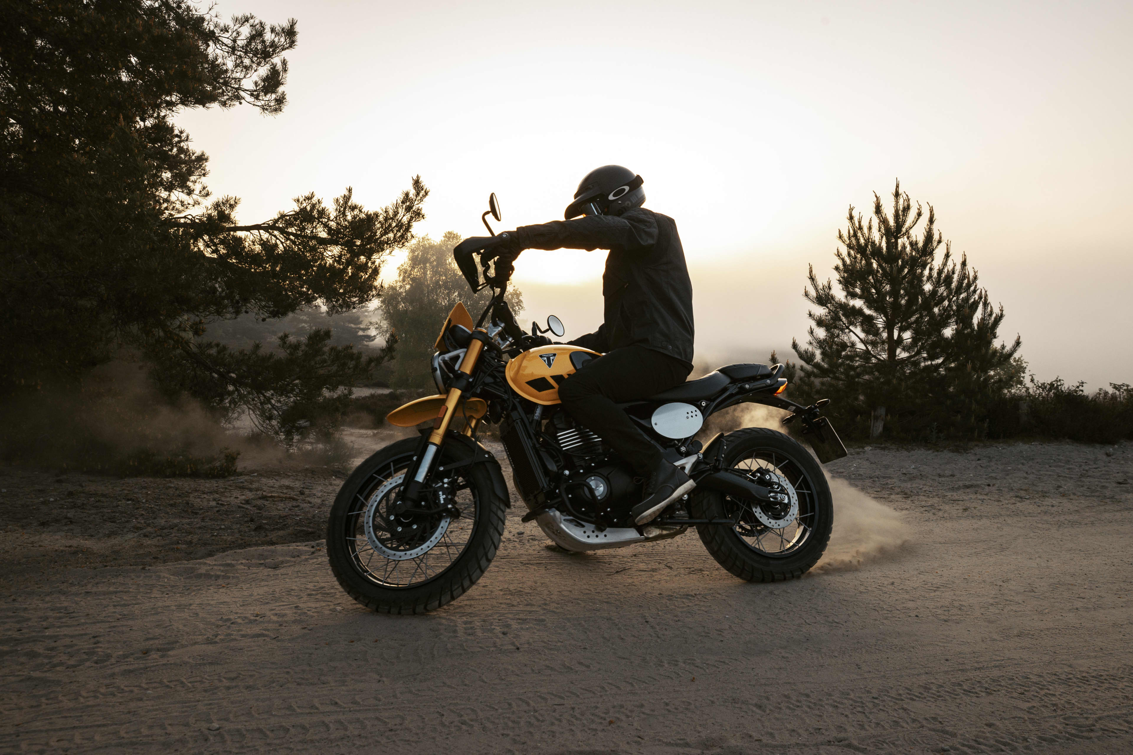 Triumph Scrambler 400 XC riding in a forest setting 