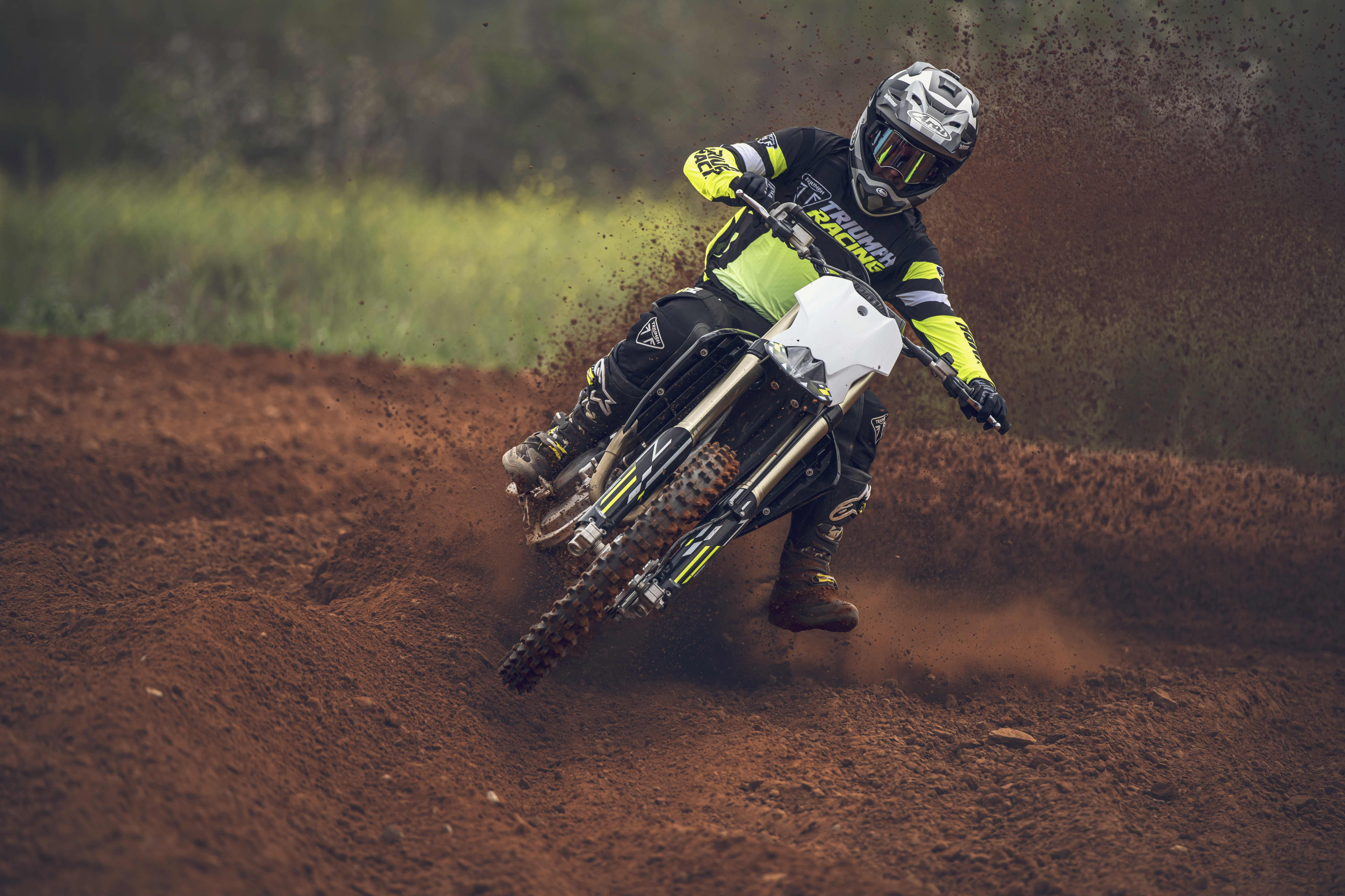 Triumph TF 250-X (MY26) riding on a red dirt motocross landscape
