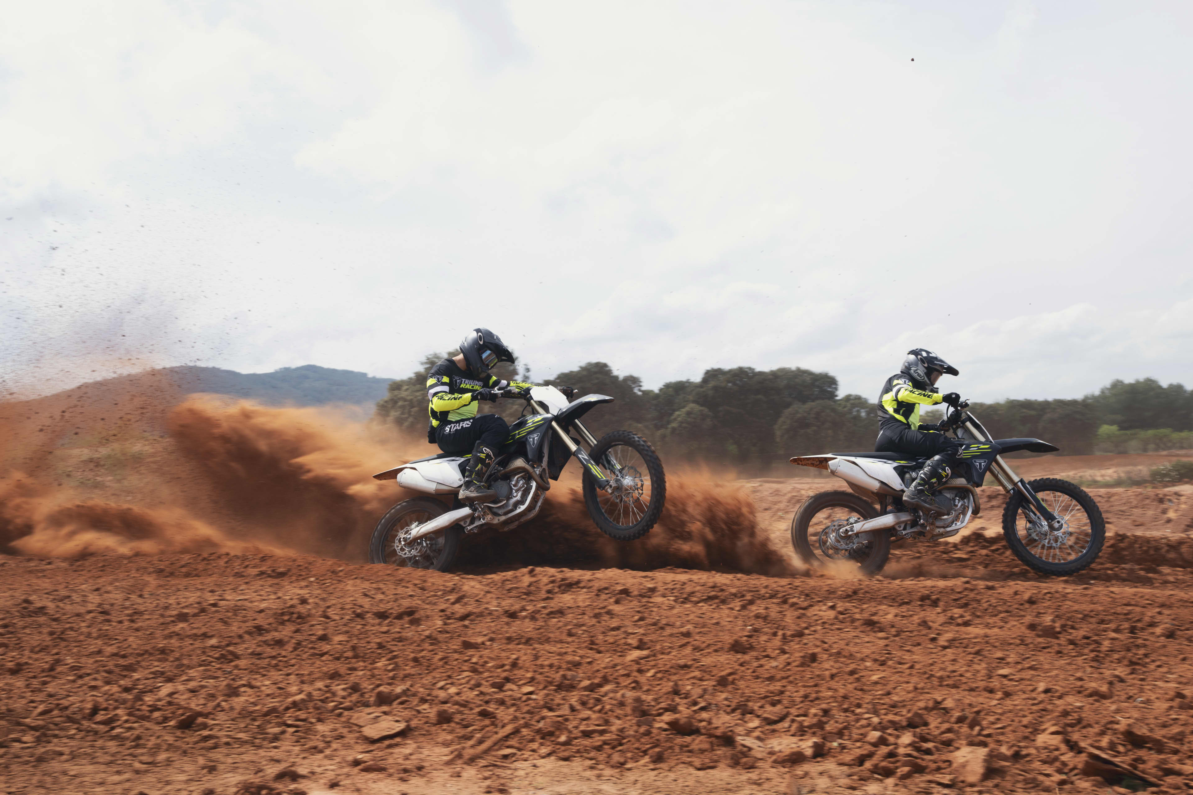 Two riders on the TF 450-X motorcycles off road riding through the dirt track
