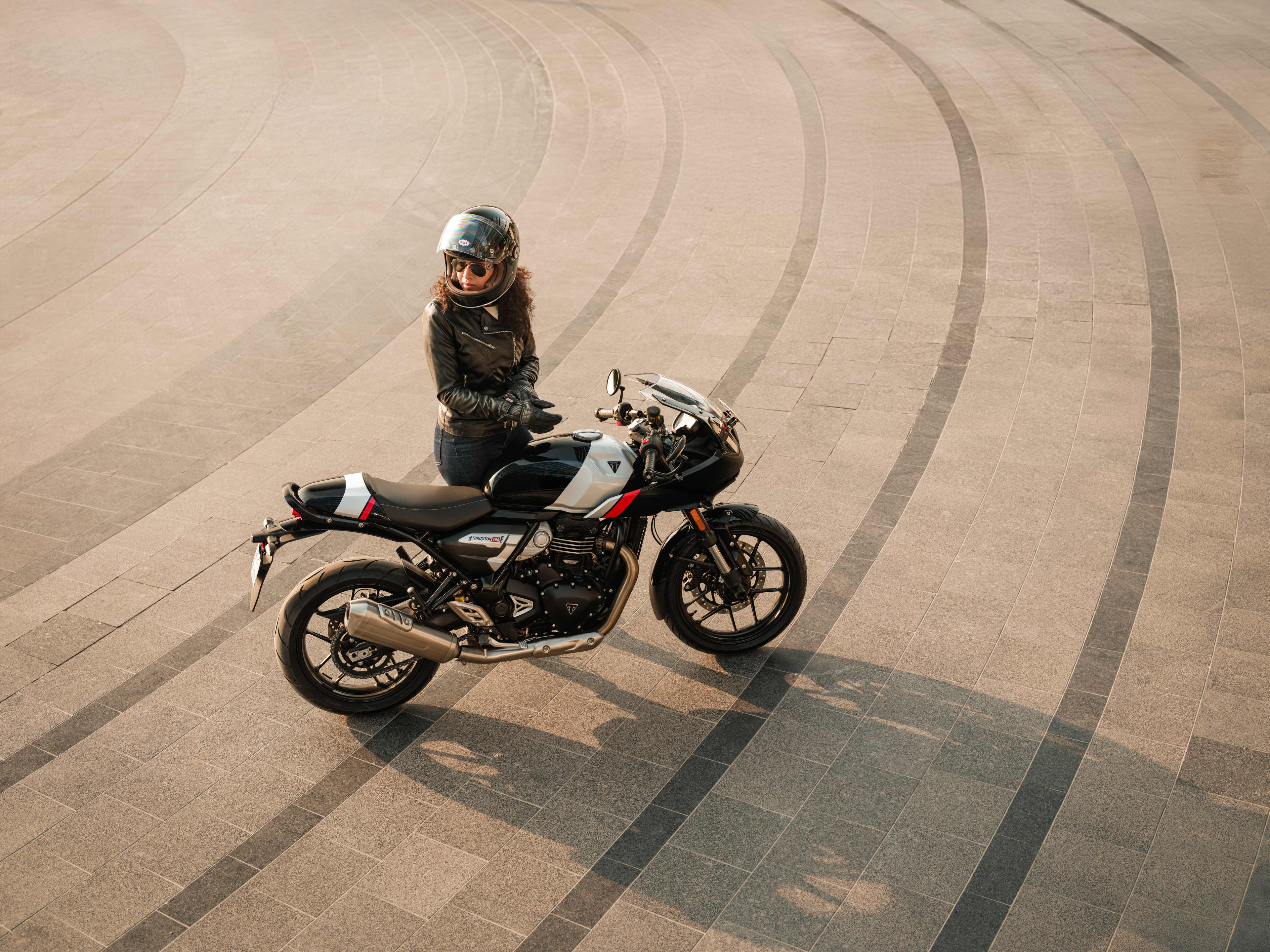 Rider standing by a Phantom black and Aluminium silver Thruxton 400