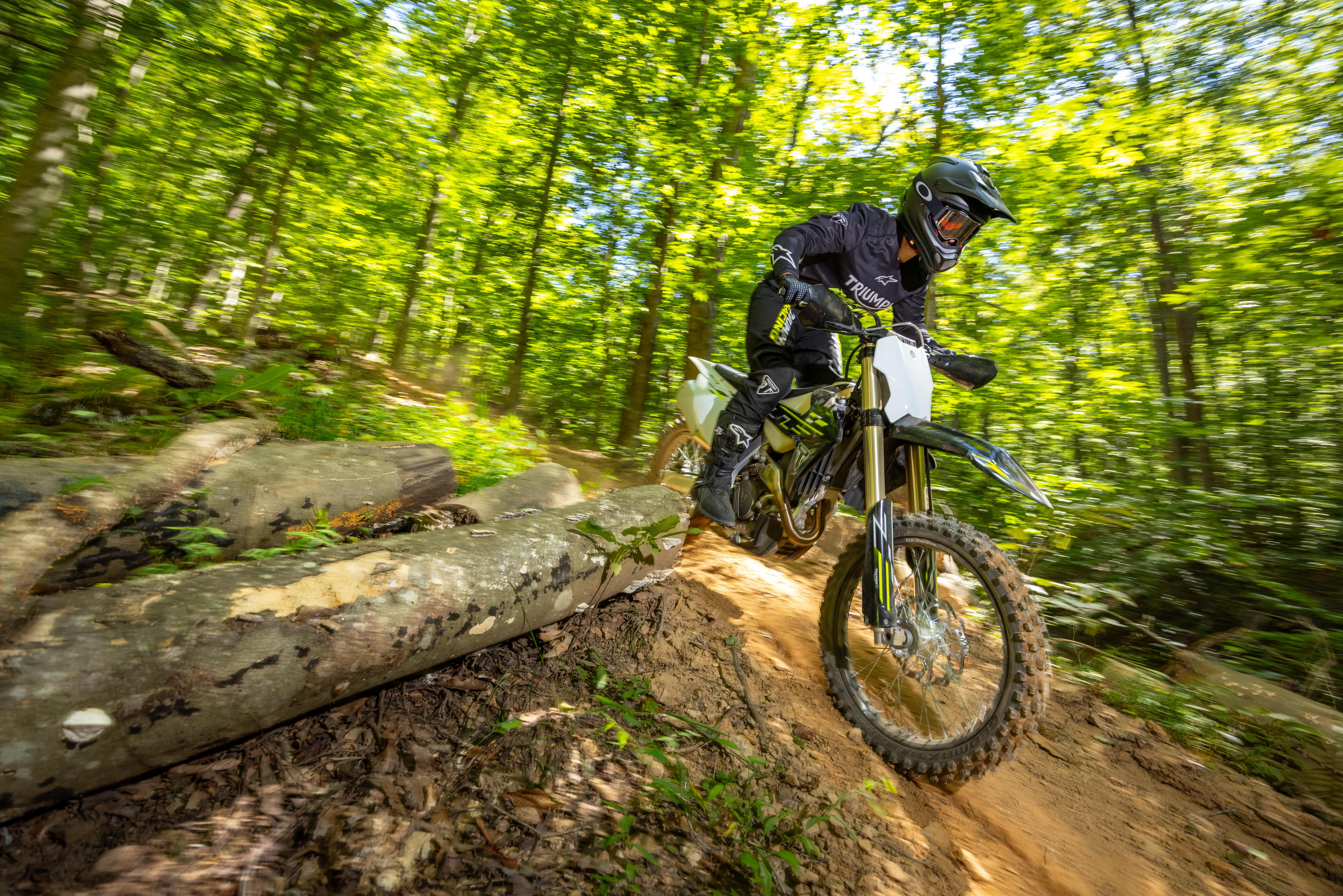 Rider on the TF 450-C motorcycle navigating through a forest track