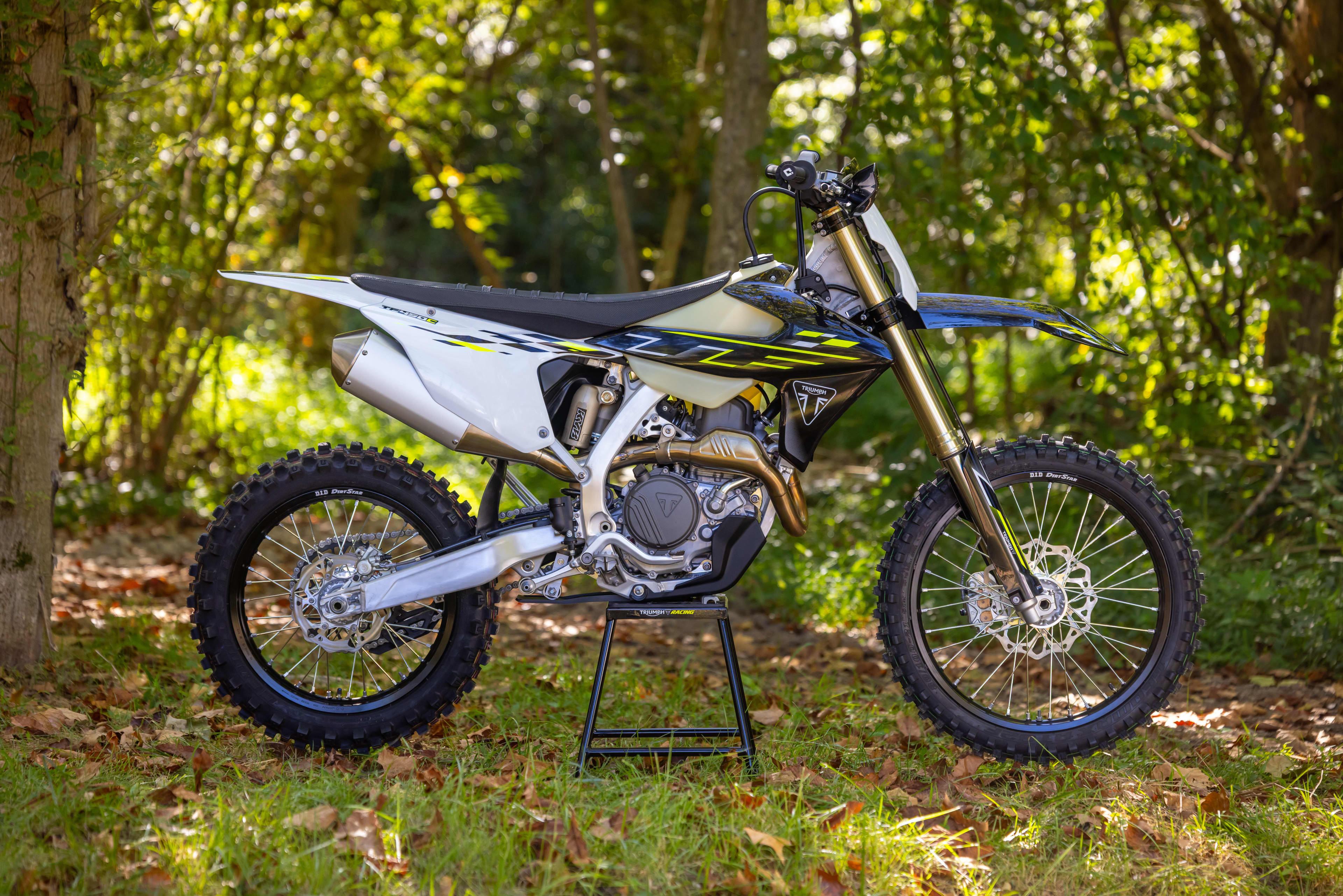 Triumph Cross Country motorcycle static shot of it parked on the stand in a forest