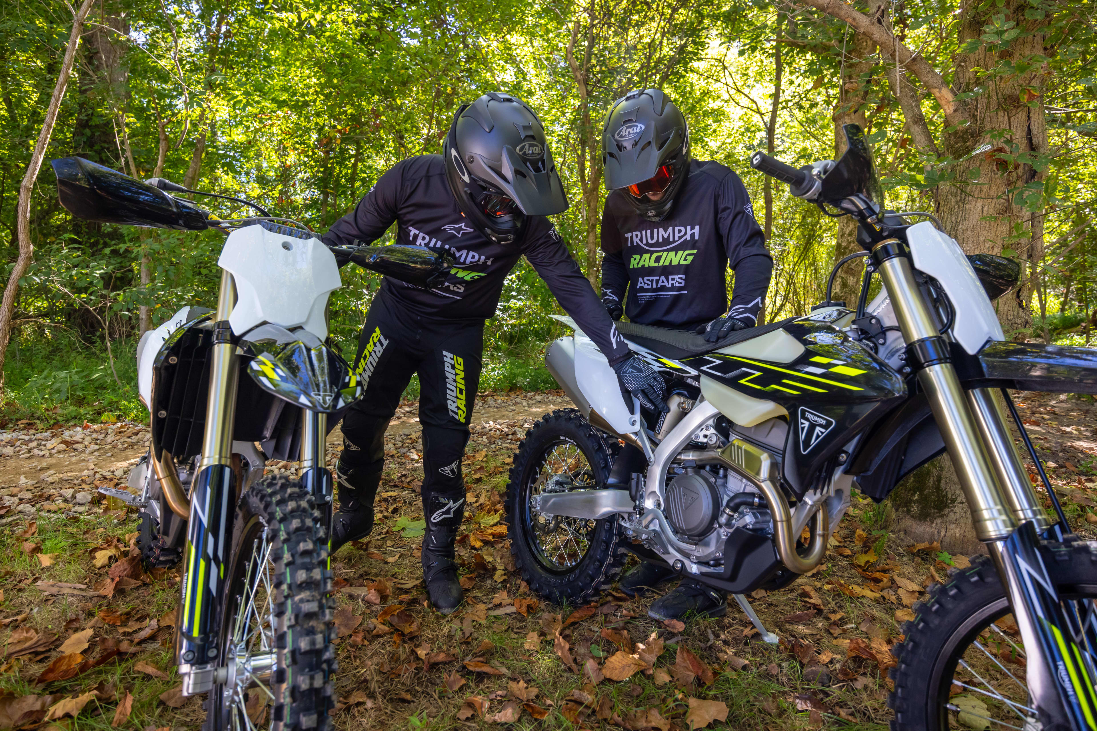 Triumph Cross Country motorcycles with two riders inspecting the bikes