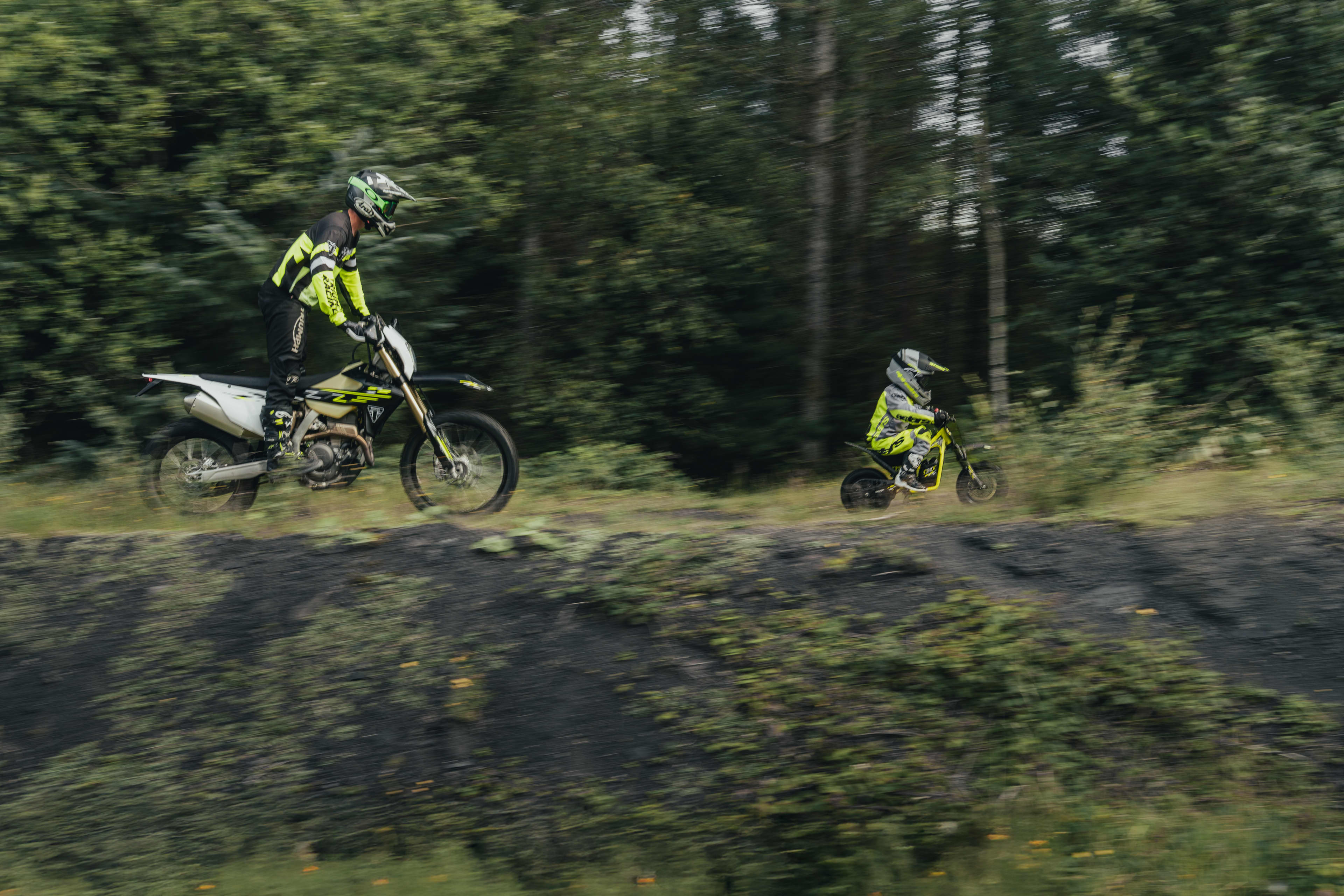 TXP-12 young rider with adult supervision following them on the forest trail.