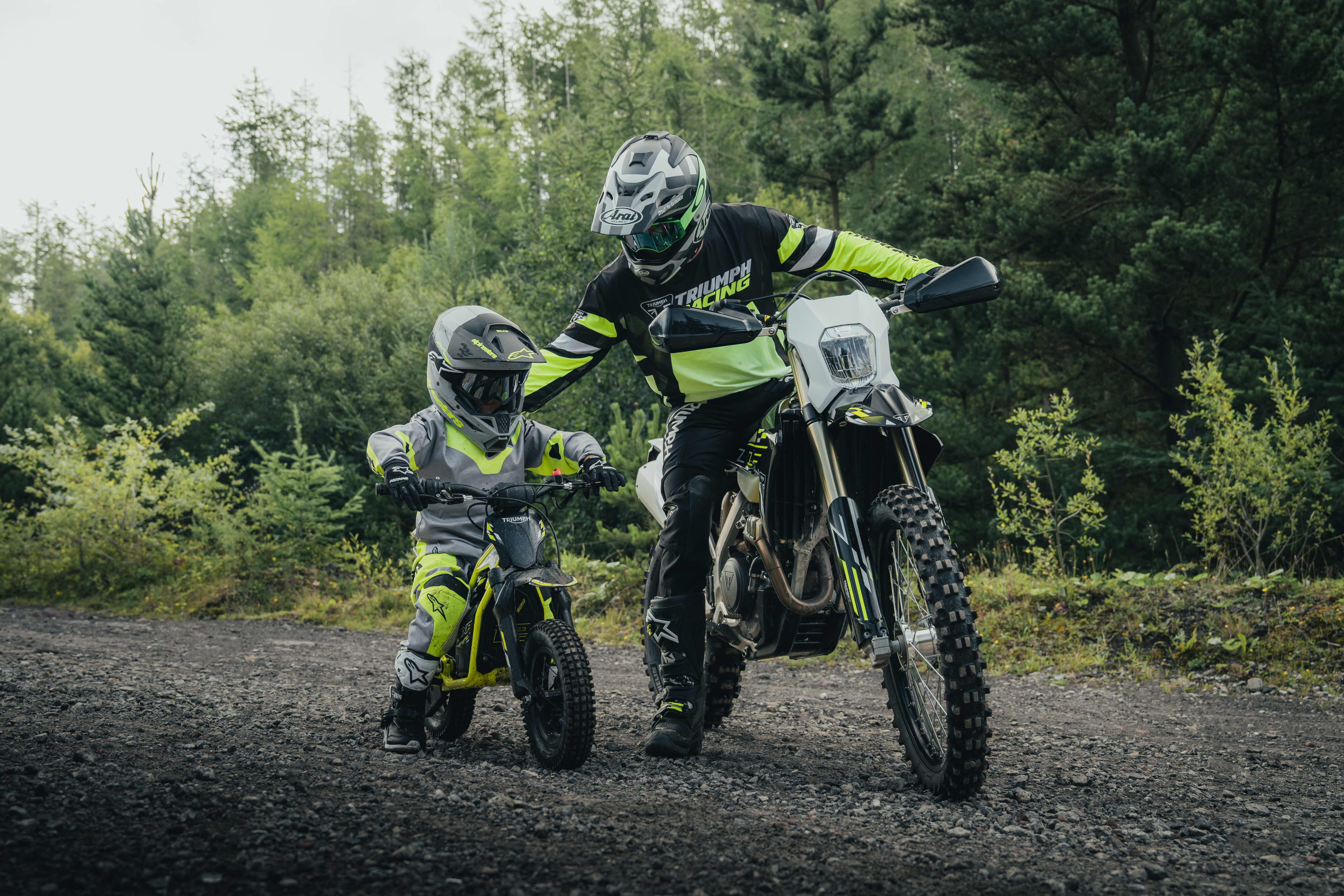 An adult explaining the TXP-12 functionality to the young rider on the bike.