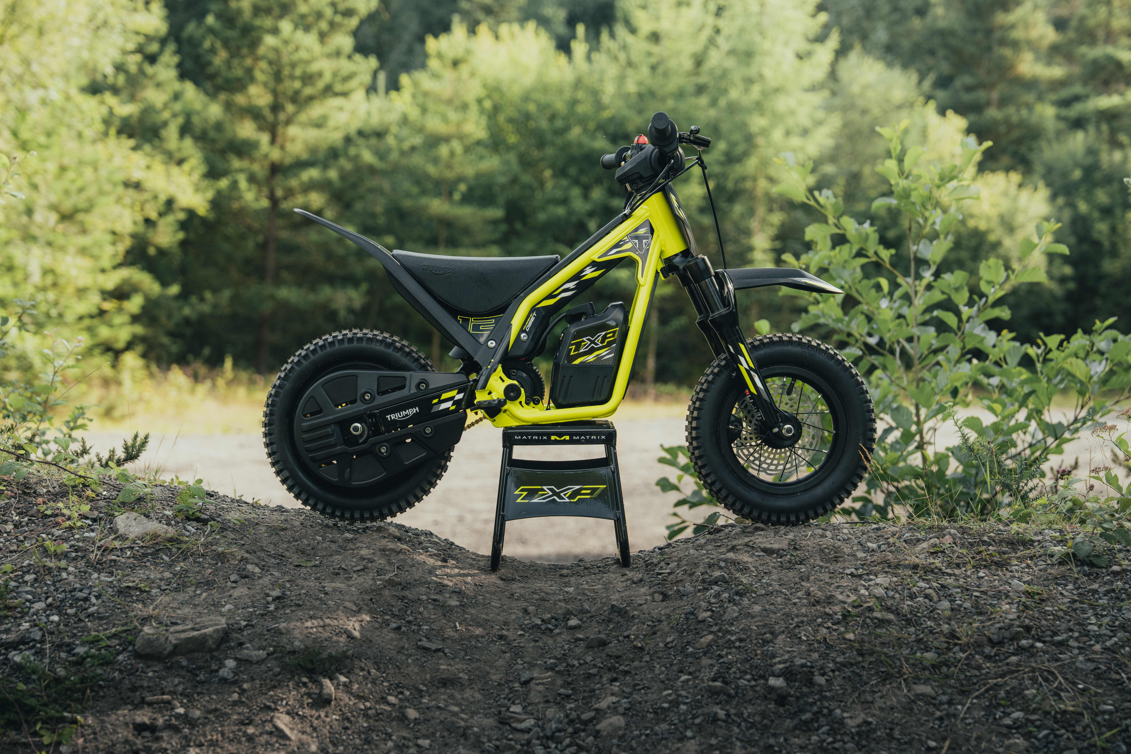 TXP-12 side on parked up on the TXP bike stand with a forest backdrop.