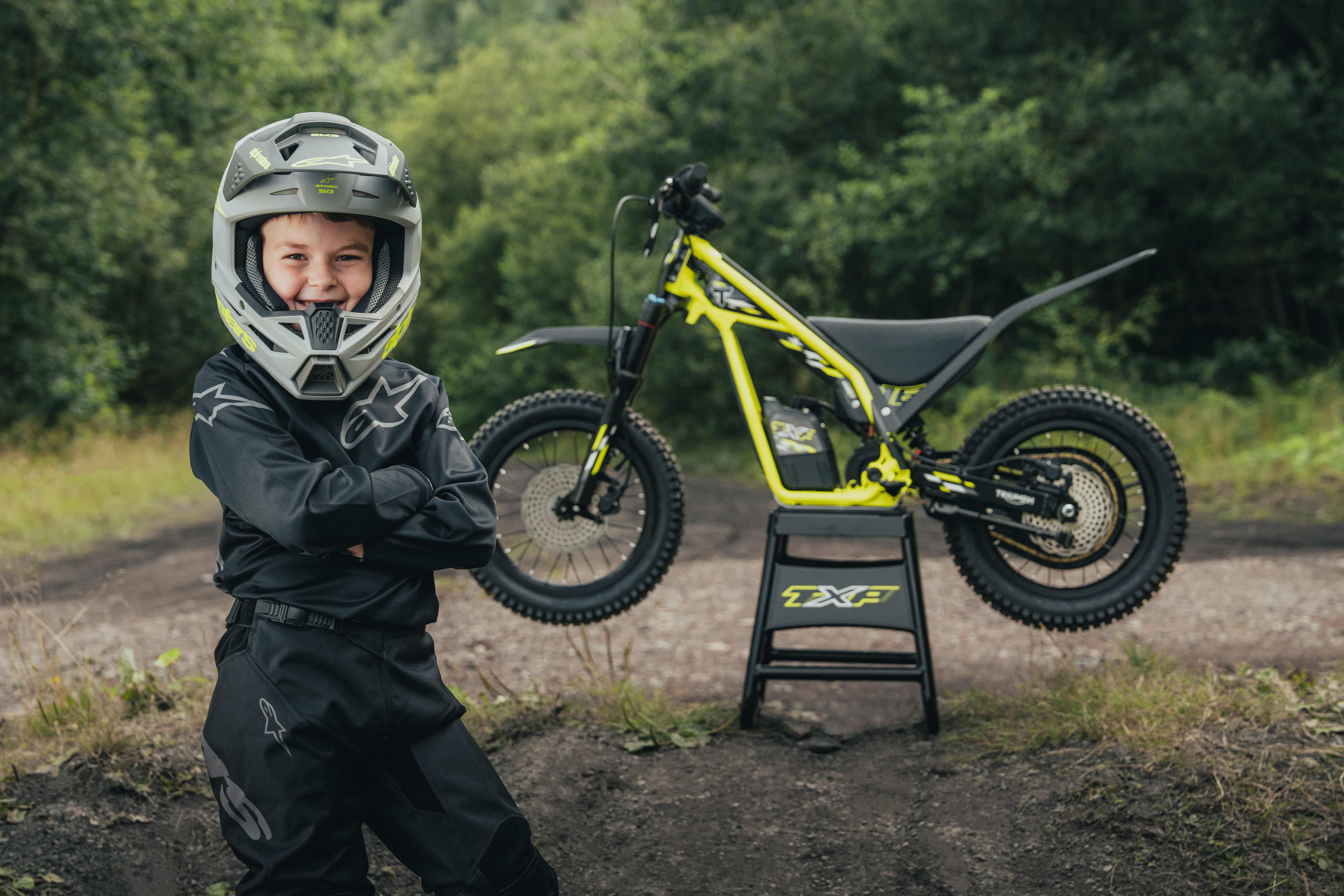 A young rider posing in front of the Triumph TXP-16 powered by OSET bike.