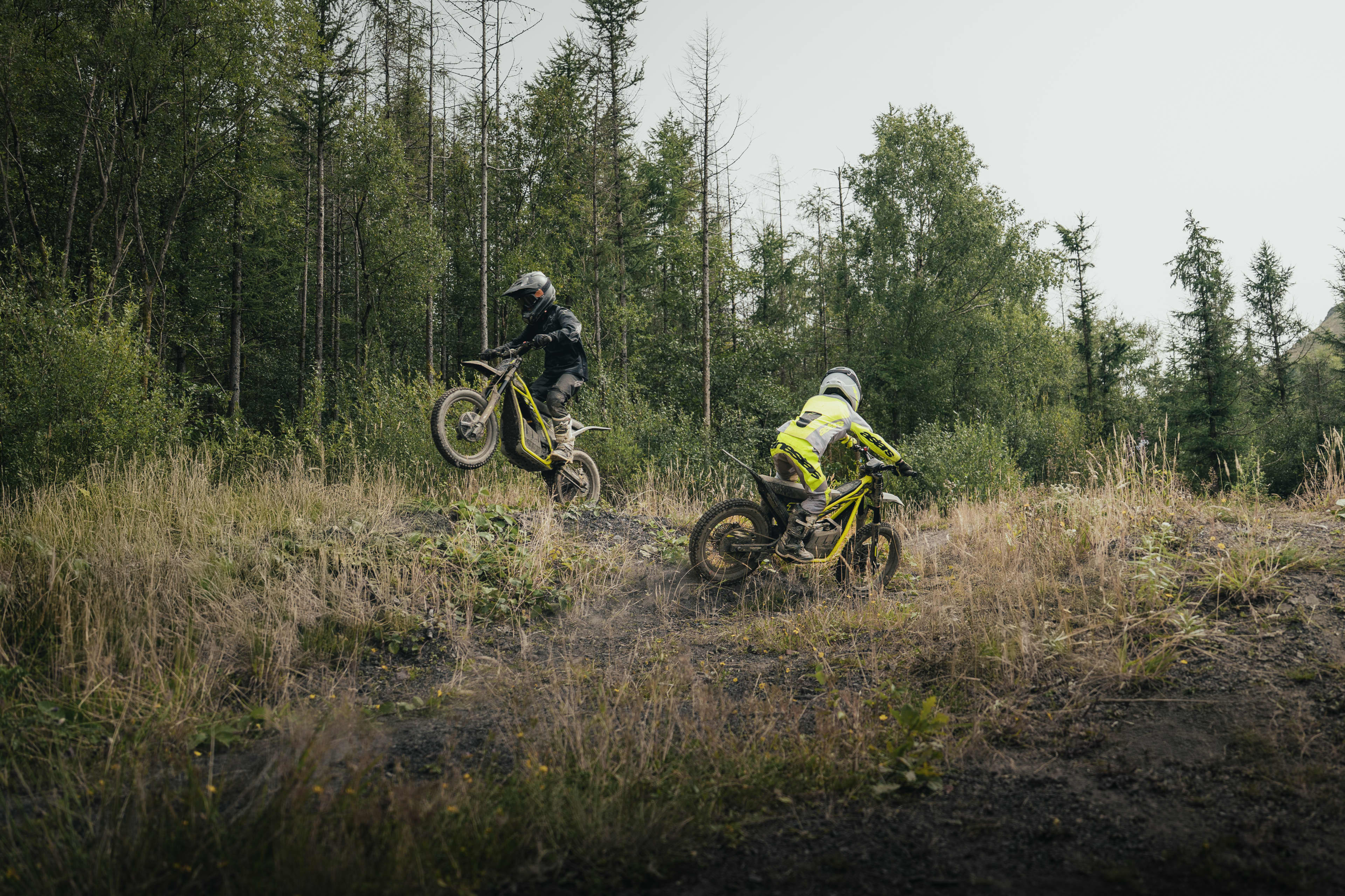 Triumph TXP-20 powered by OSET bikes with two young riders in a forest setting.