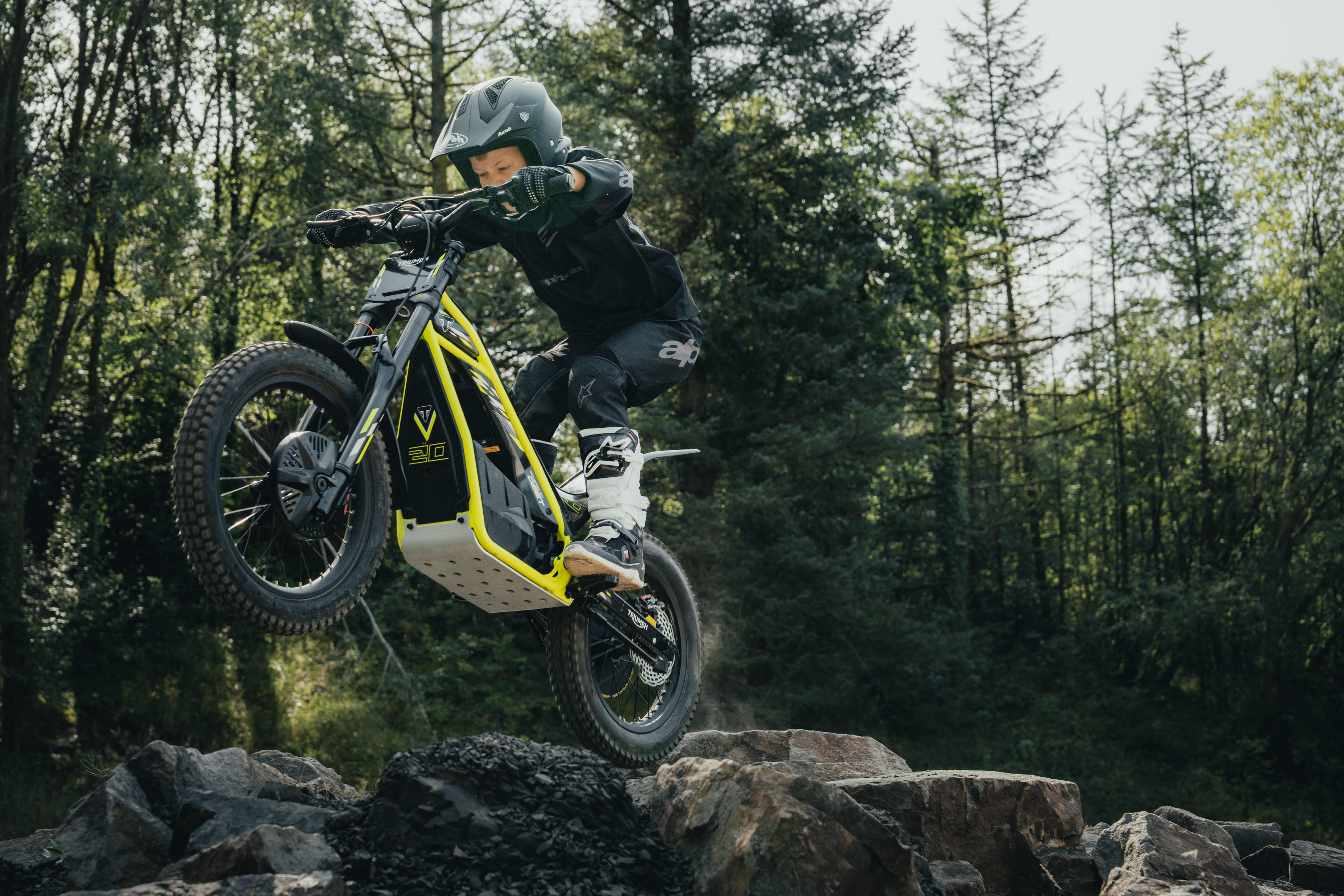 TXP-20 powered by OSET bike going over a rocky terrain in a forest.