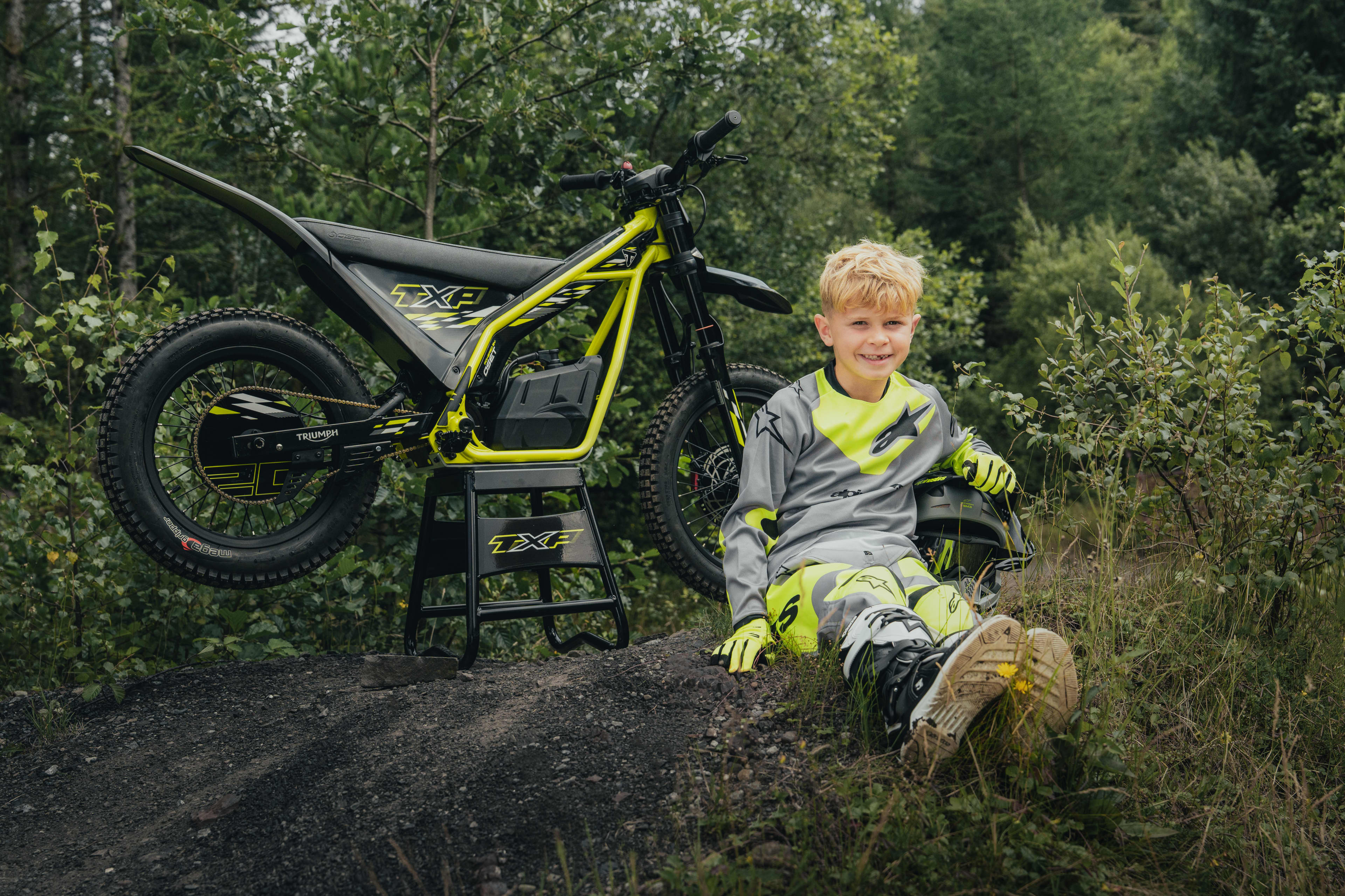 TXP-20 powered by OSET bike parked up with the young rider sat in front of the electric bike.