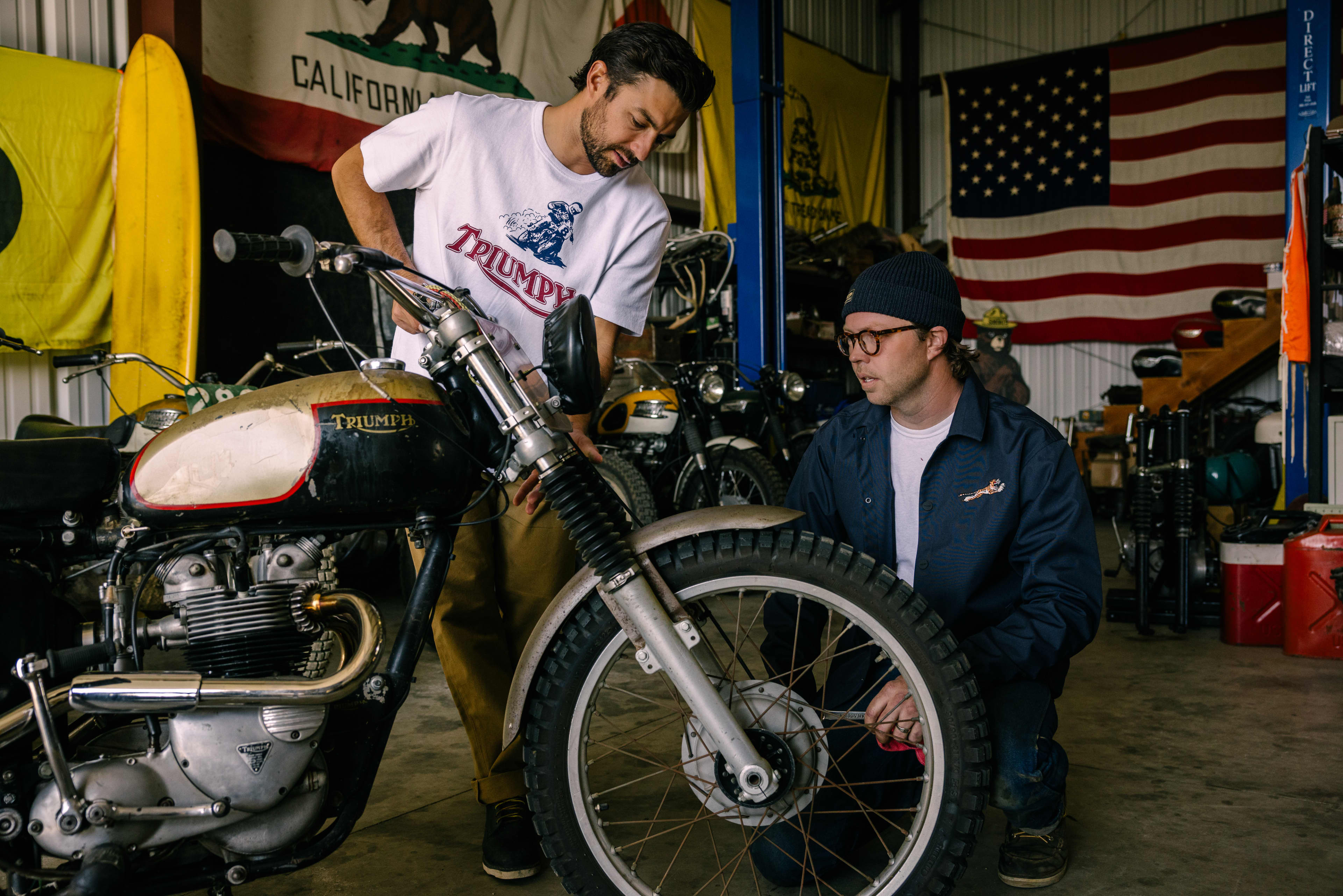 Two men looking at a Triumph Motorbike whilst wearing Triumph Heritage Clothing